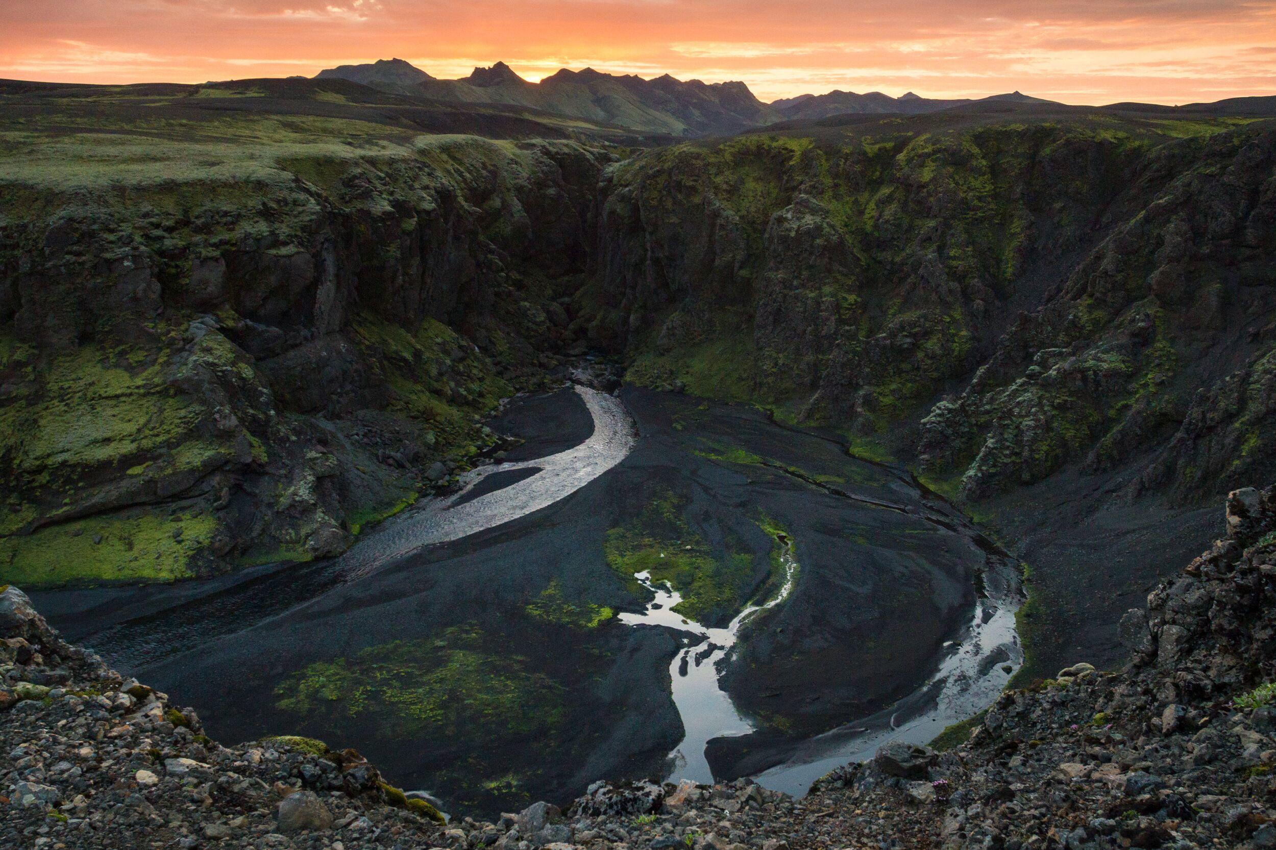 Sunset at Hvanngil: Serene Green Landscape Meets Black Sand and River's Flow