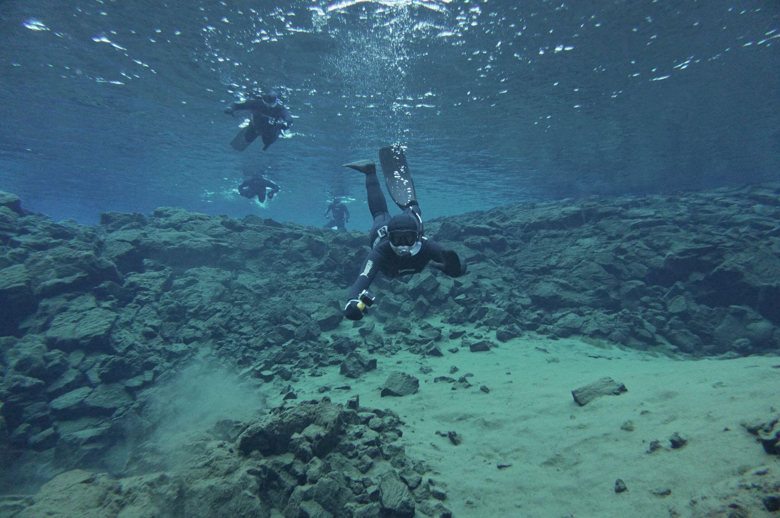 Scuba divers swimming thorugh the Daviðsgjá