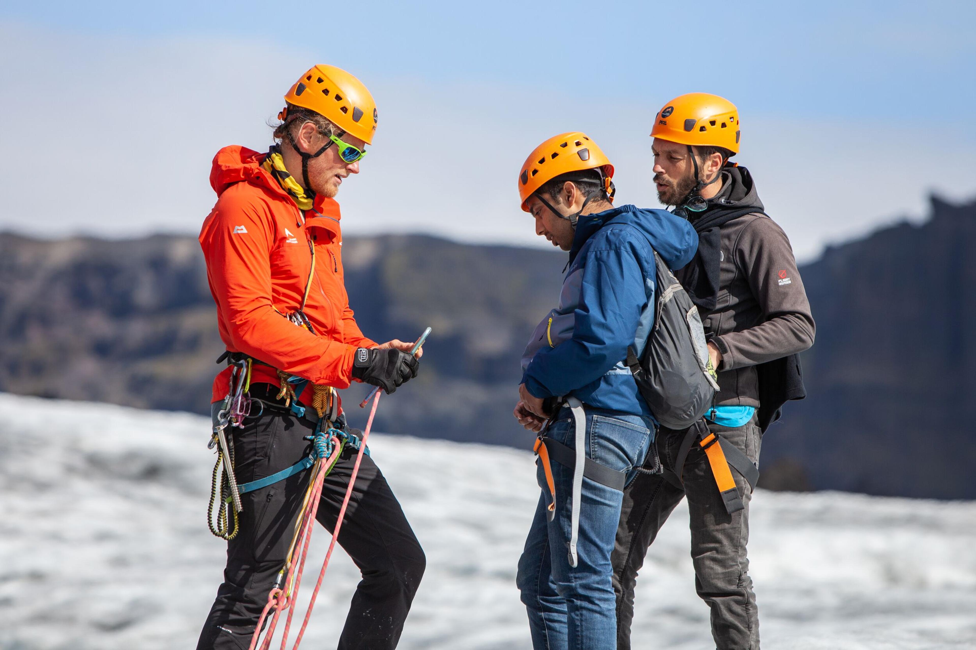 A professional guide with a group of tourists hiking on Sólheimajökull Glacier in the south coast of Iceland.