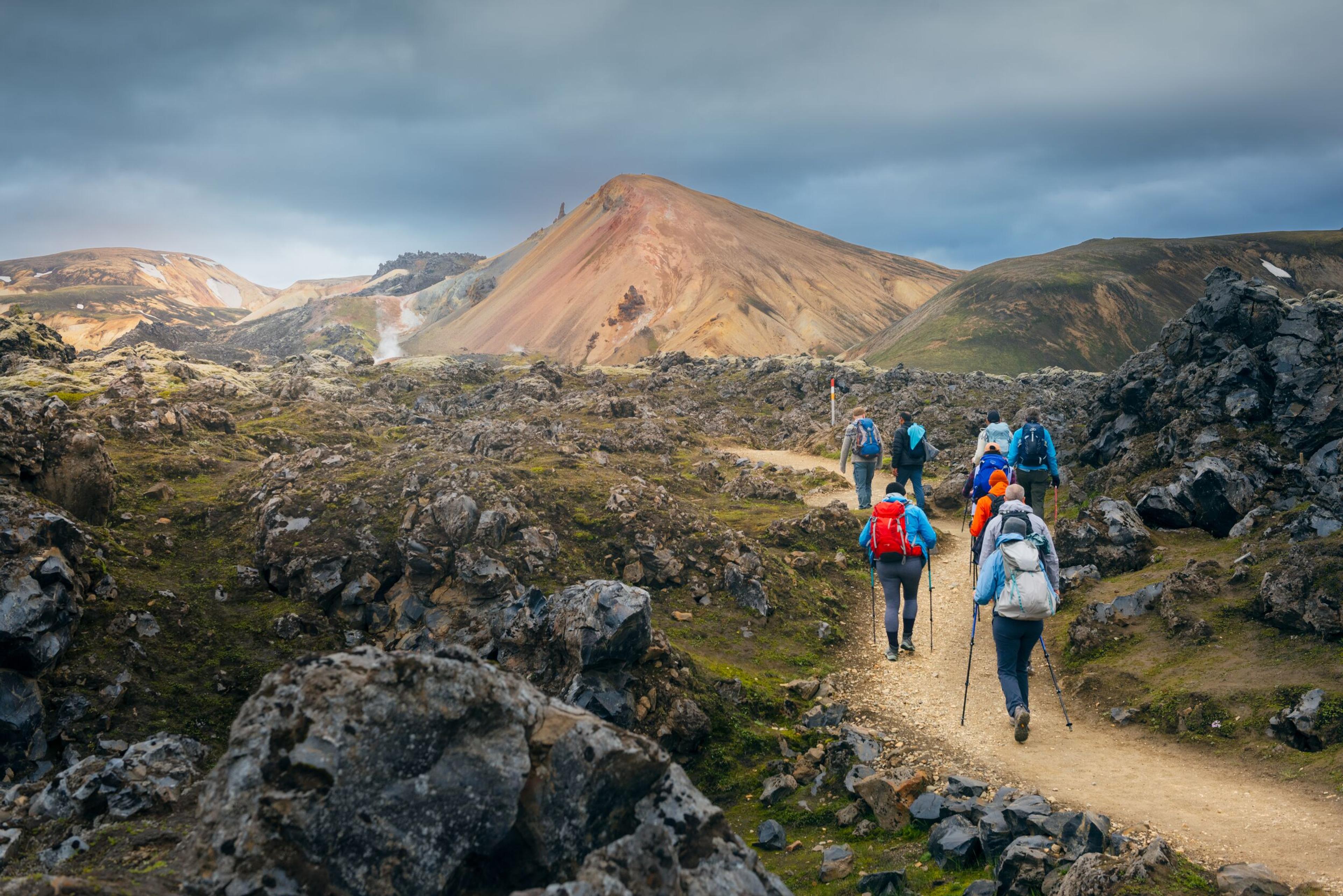 Hikers navigating through the ancient lava fields of Landmannalaugar.
