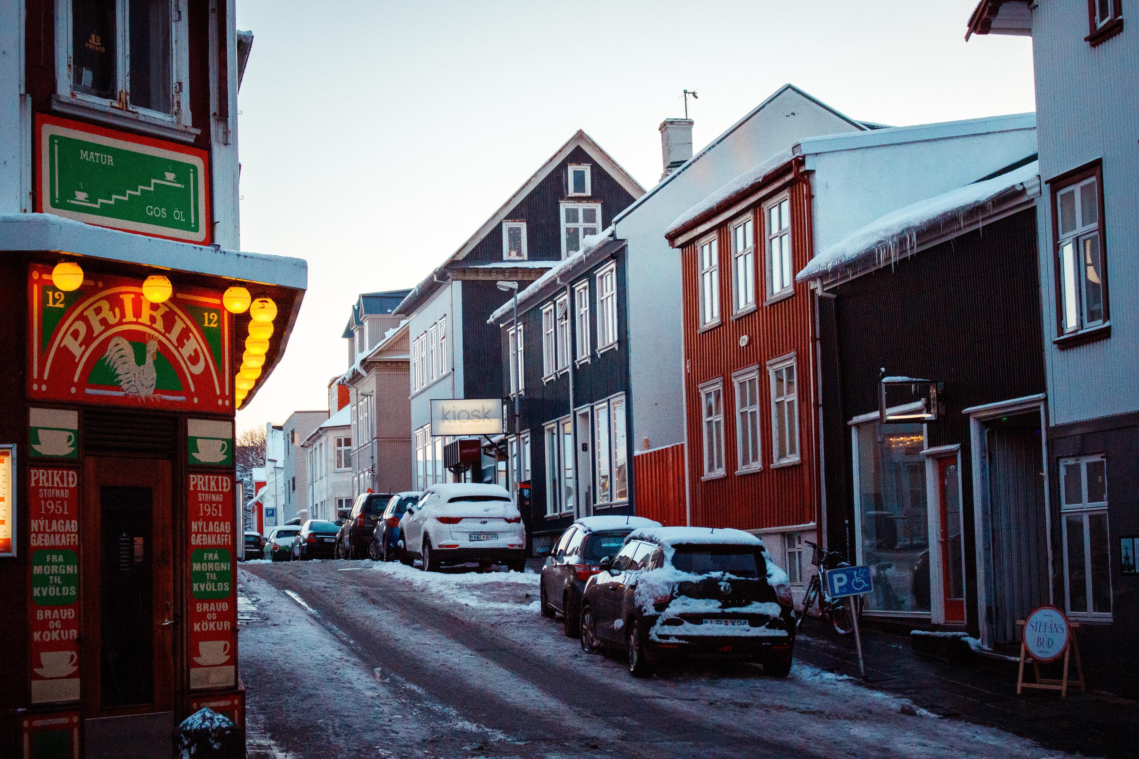 A snowy street scene in an Icelandic town during twilight with colourful houses