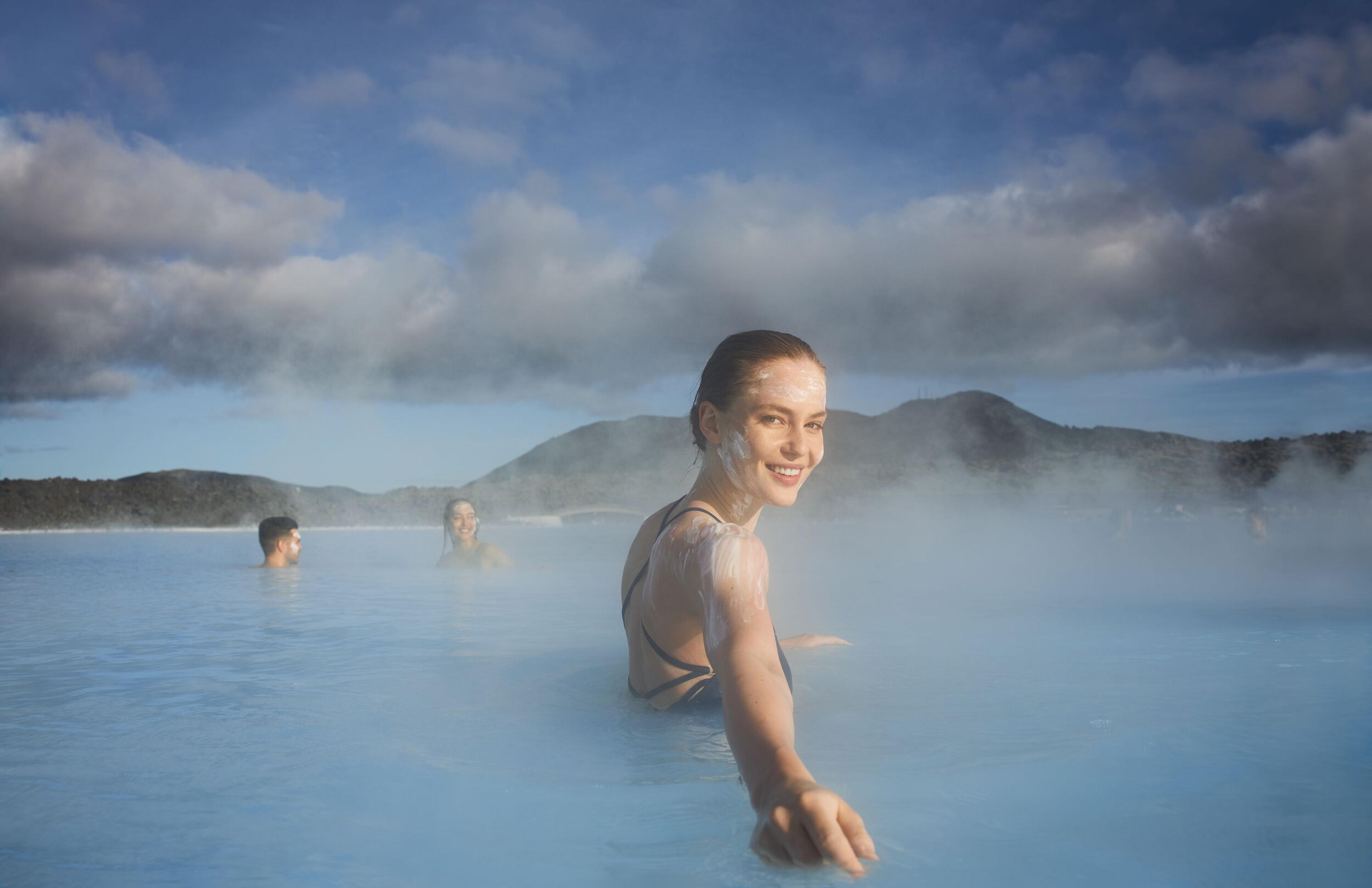 An woman with silica mud masks on her face, basking in the warmth of the Blue Lagoon