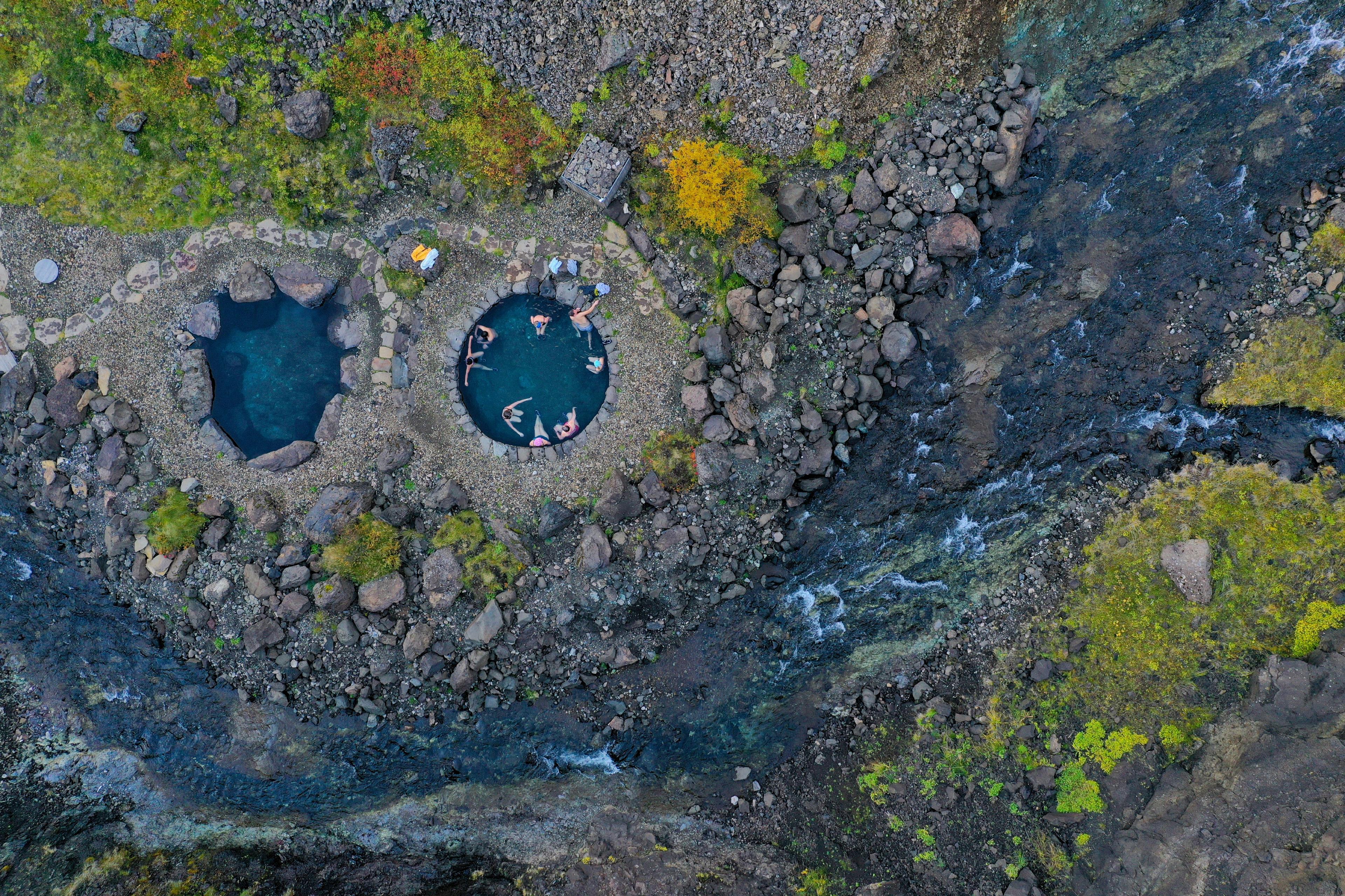 Overhead image of people leisurely relaxing in small round warm pools.
