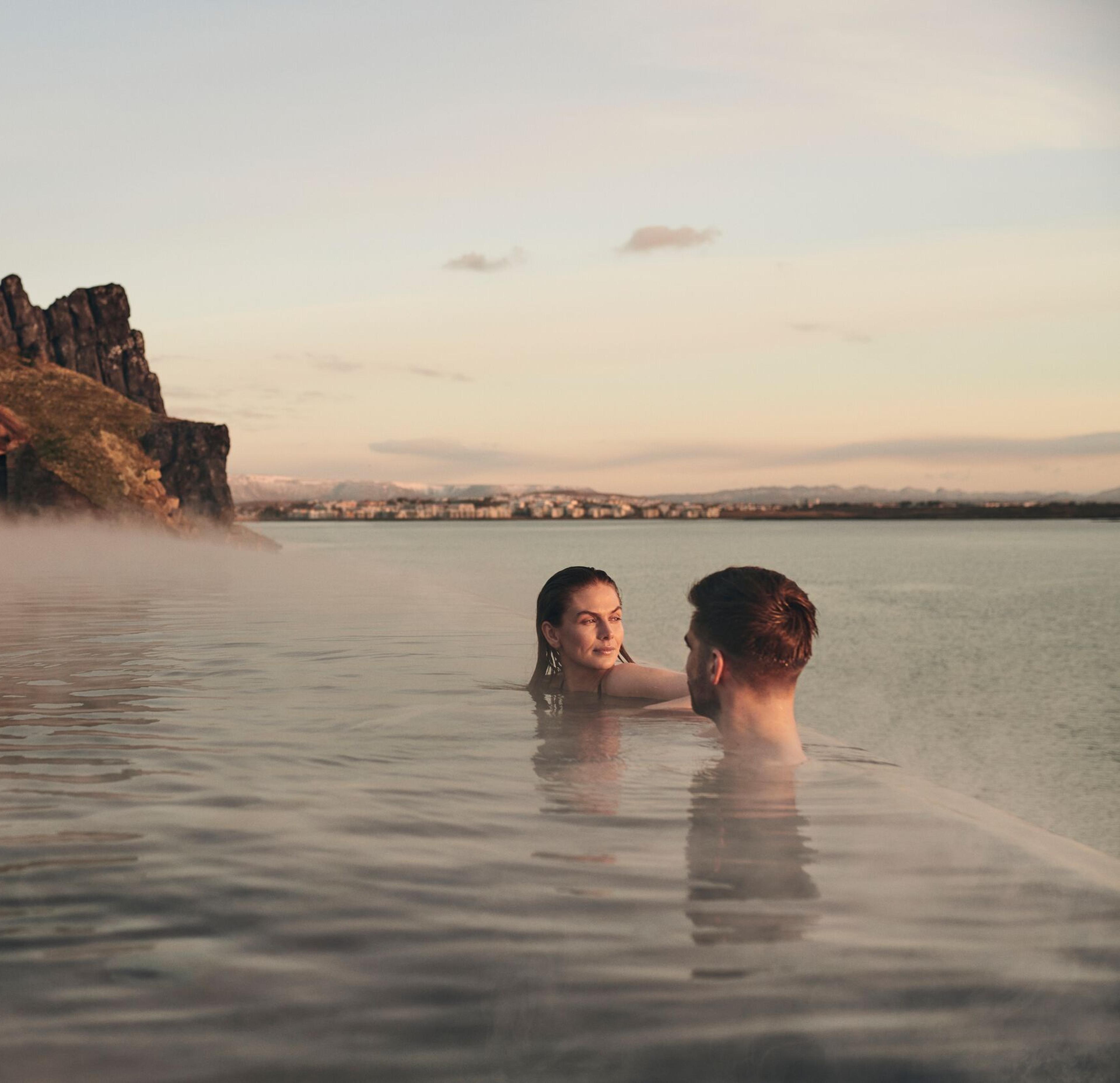A couple unwinding at the edge of Sky Lagoon's infinity pool