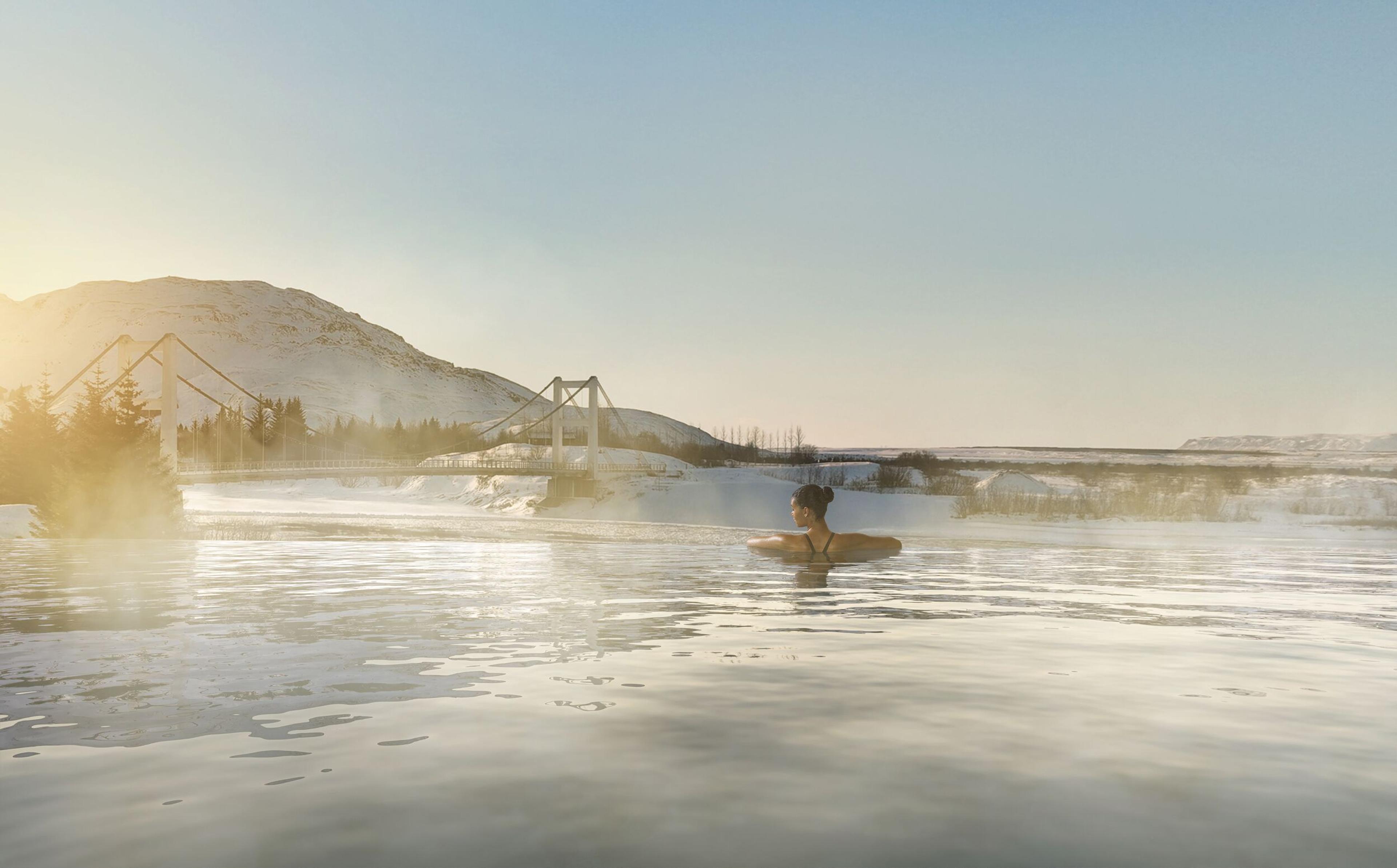 a woman is swimming in a lake with mountains in the background .