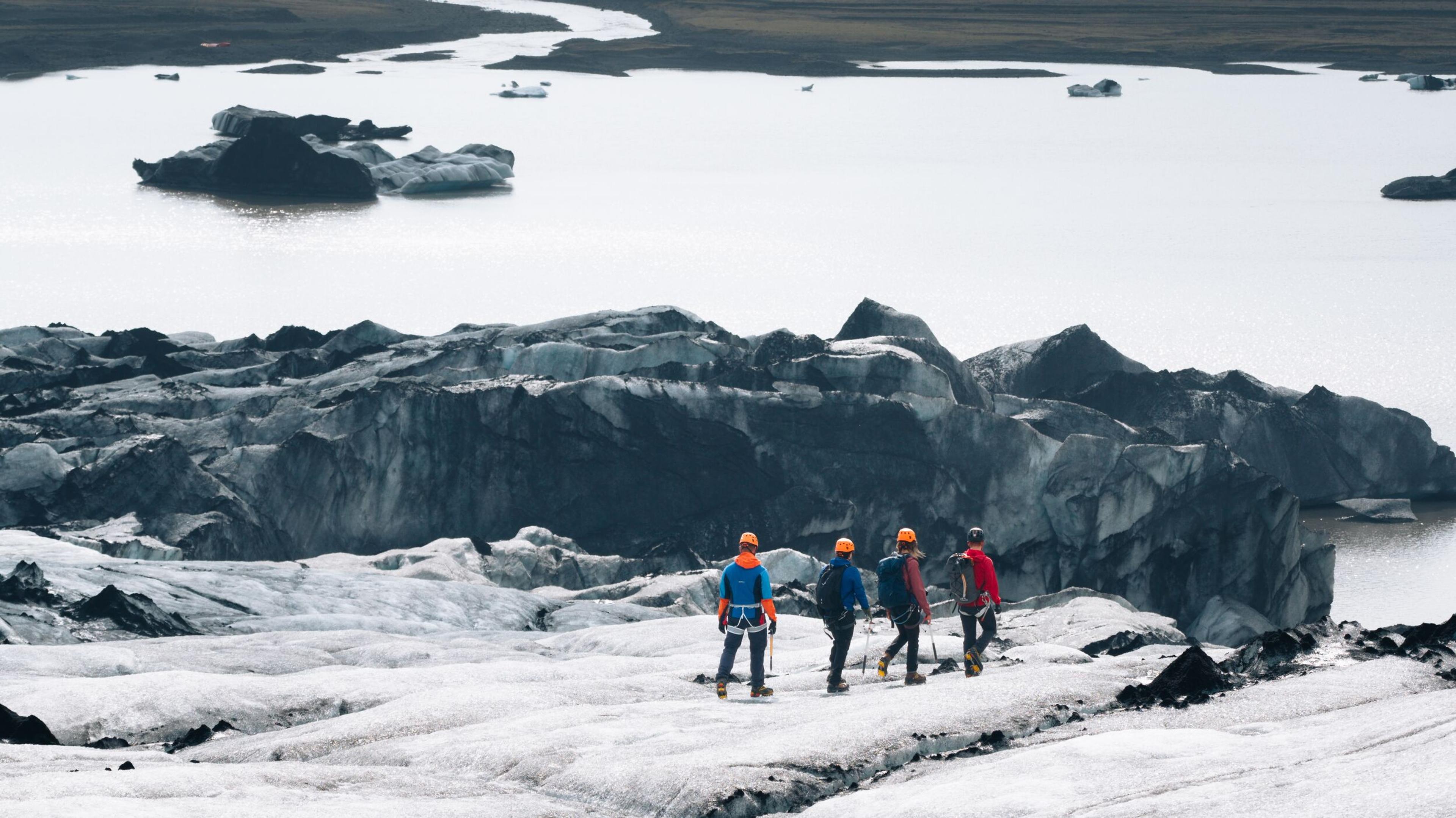 a group of people are walking on top of a snow covered mountain .