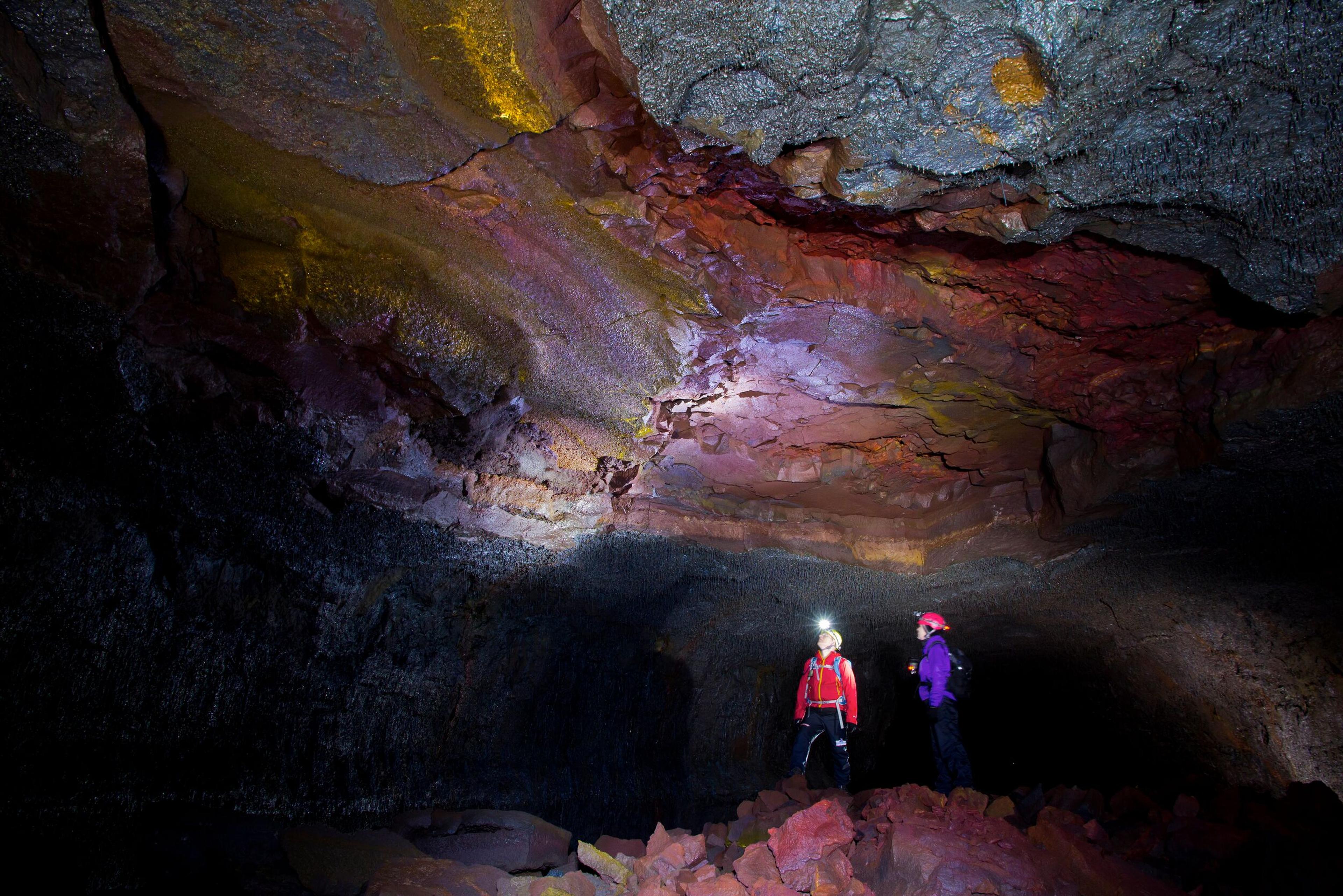 Two explorers inside a lava cave in Iceland