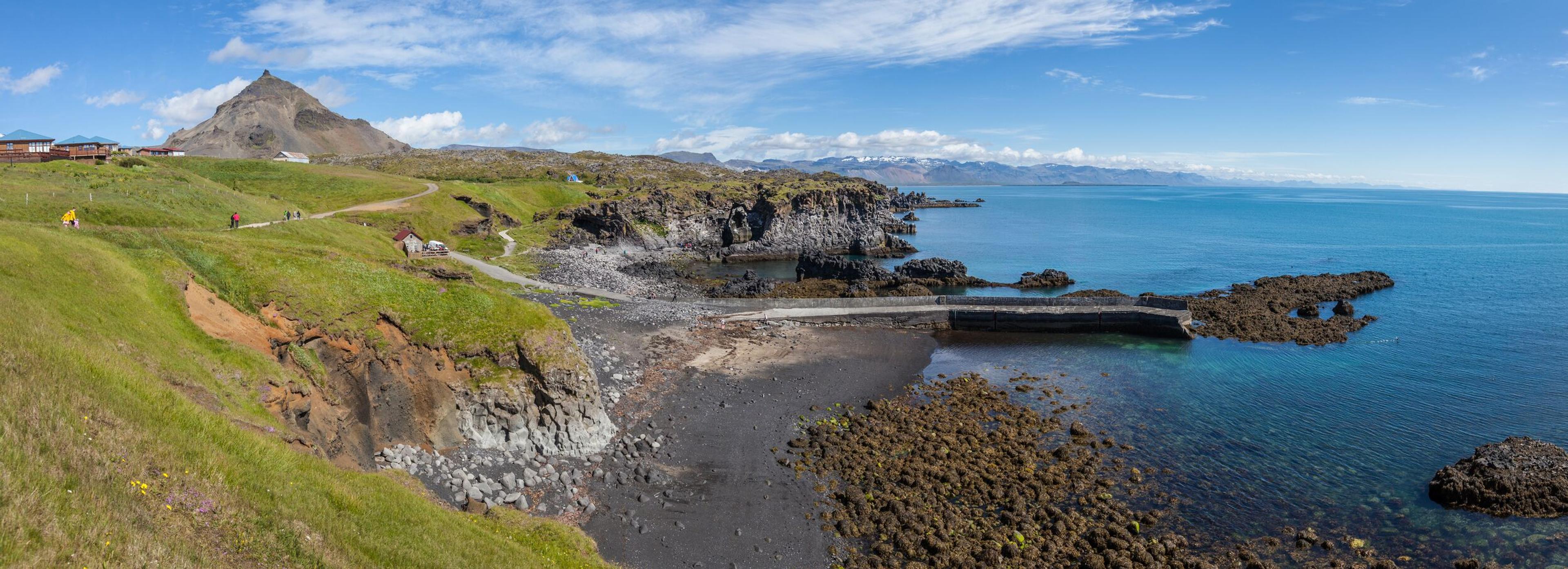 Green Grass on the Left, Small Beach in the Middle, and Ocean on the Right, Featuring an Old Port and a Cozy Café Hu