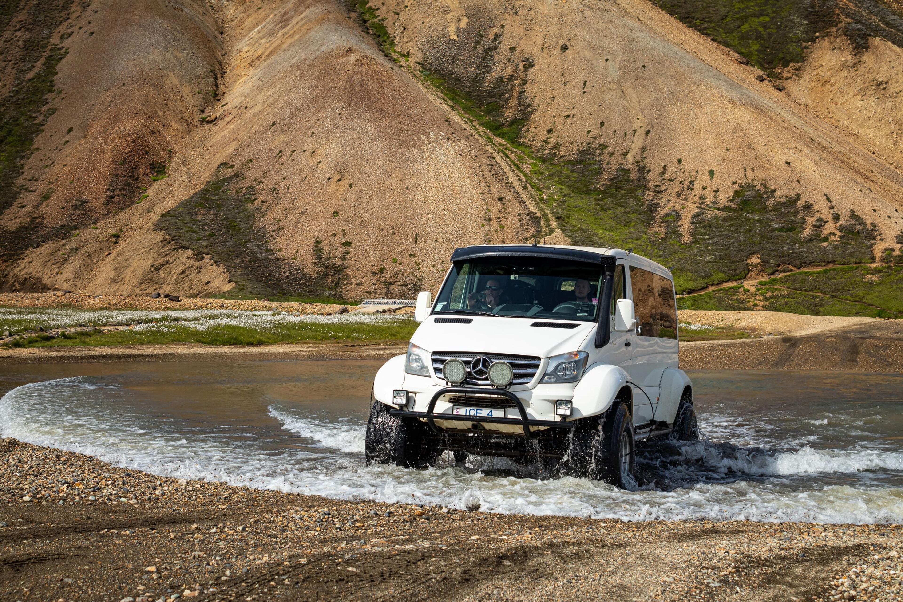 Front view of a superjeep crossing a river in the Iceland Highlands during a Landmannalaugar tour.