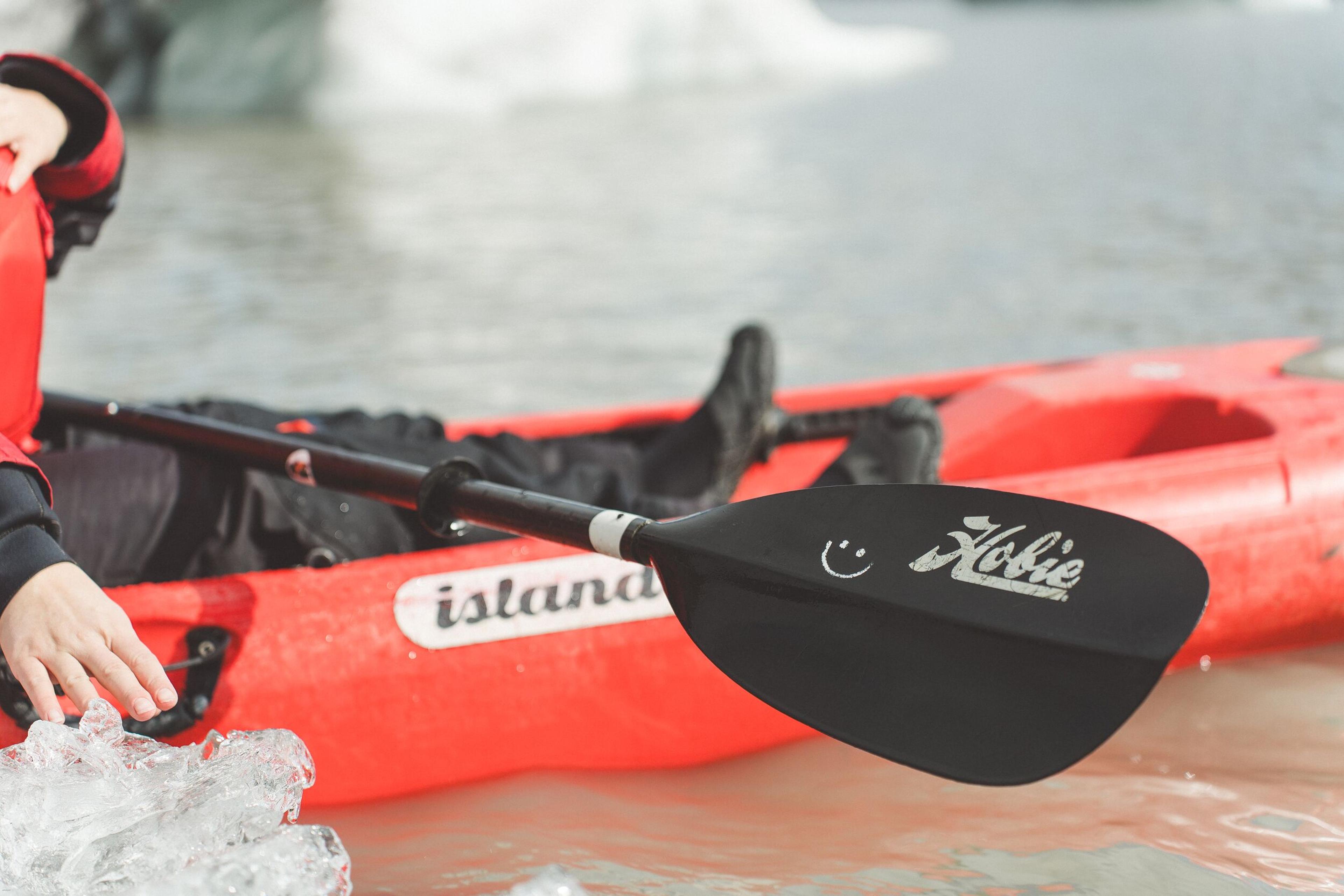 a person is paddling a red kayak in the water .