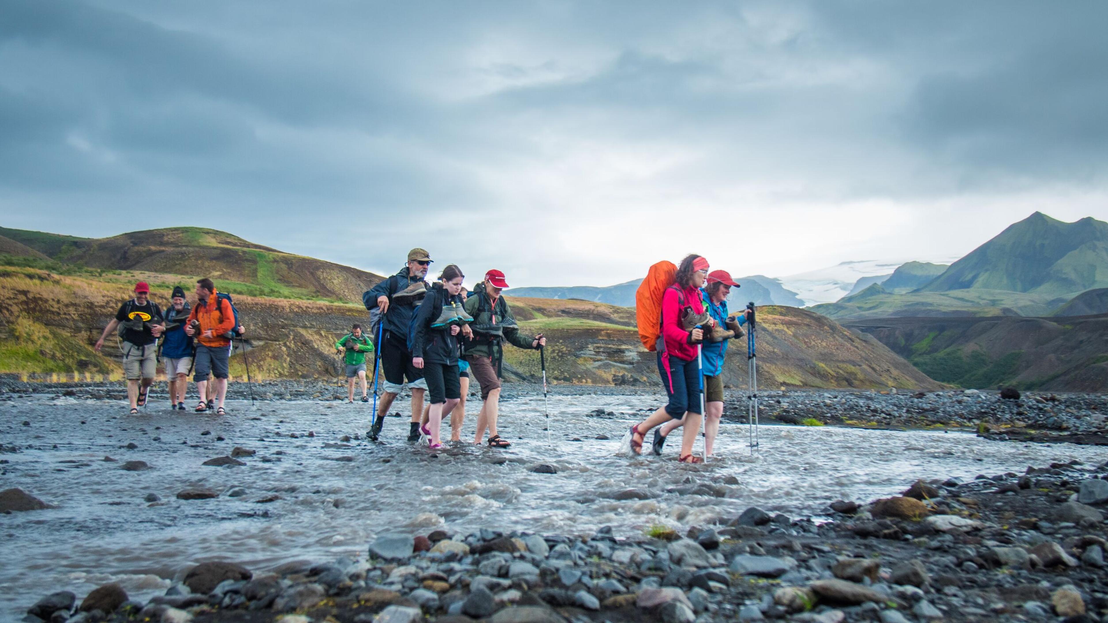  Group of people crossing a river in the icelandic highlands.