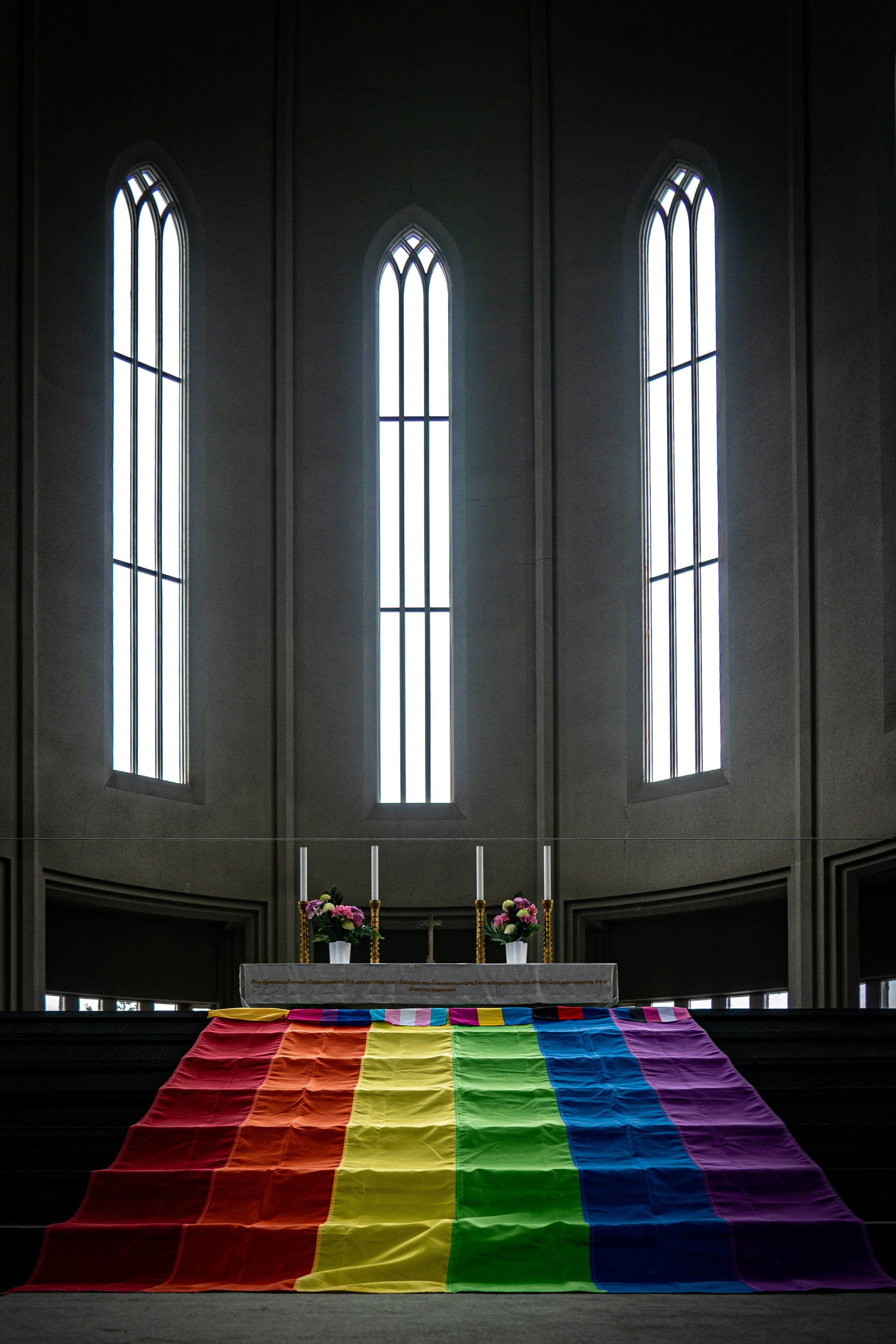 Rainbow flag draped over altar steps inside Hallgrimskirkja church, highlighting Reykjavik Pride.