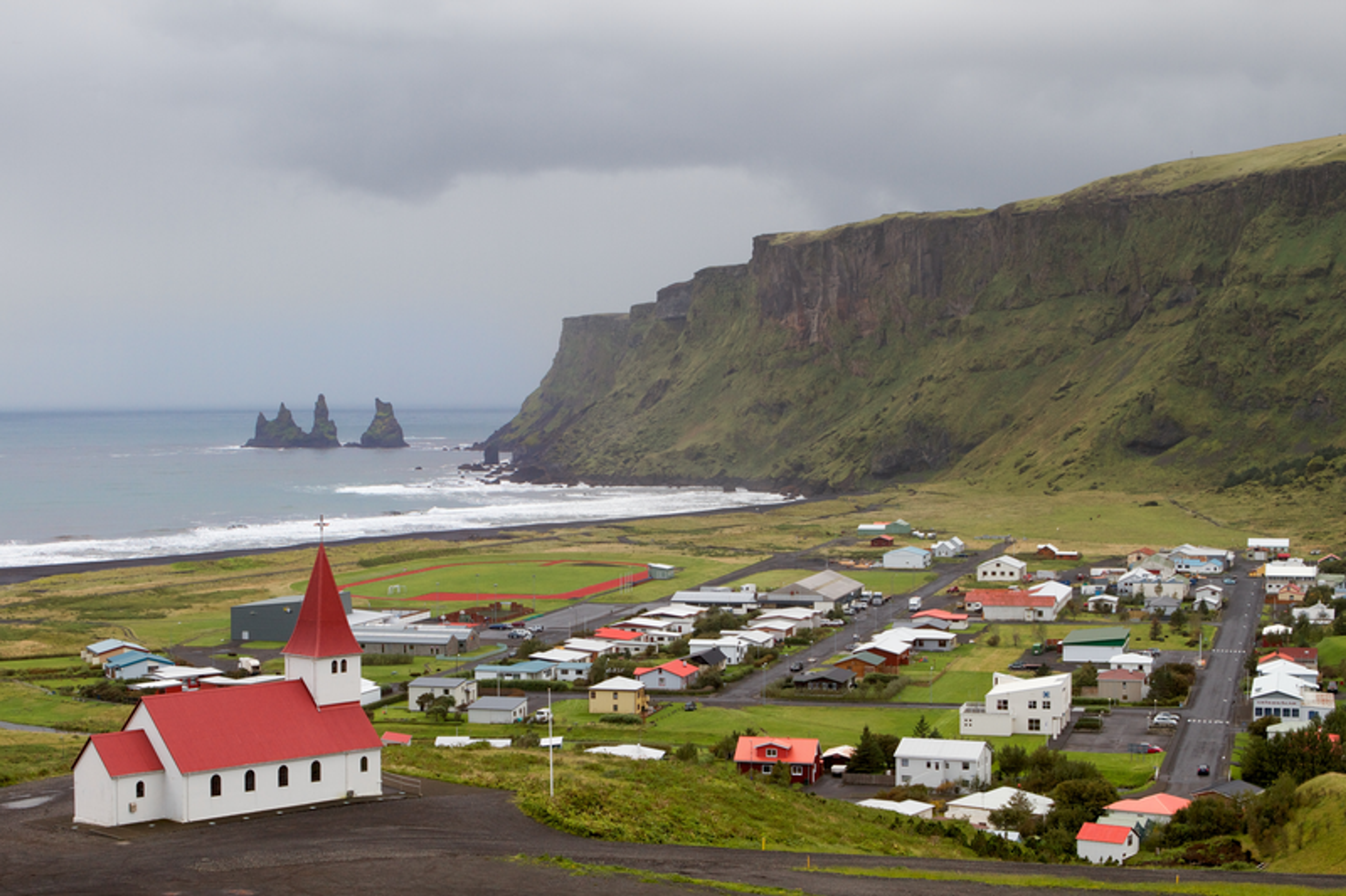 A view over the town of Vík with a church on the foreground.
