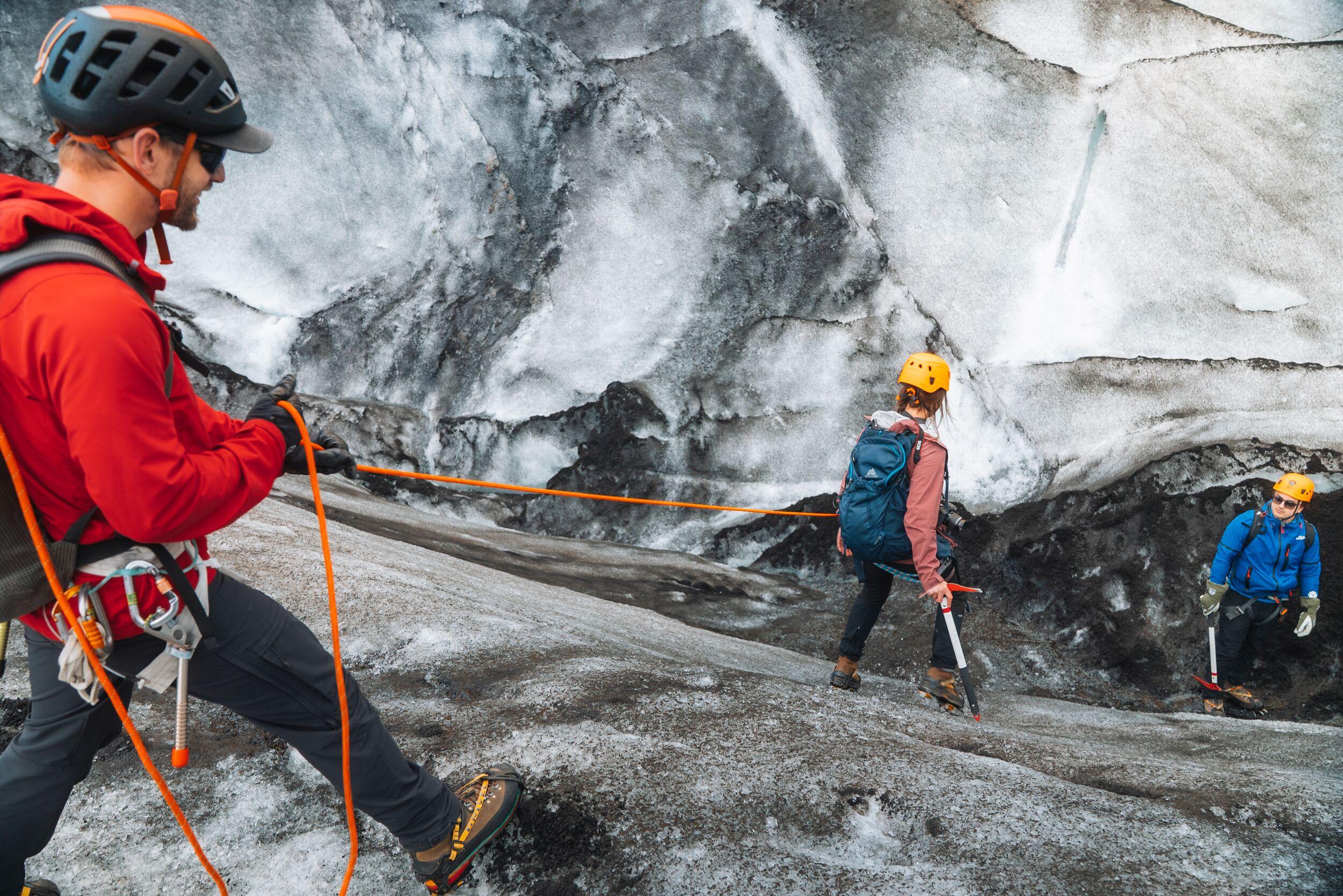 a group of people are hiking on a glacier ridge