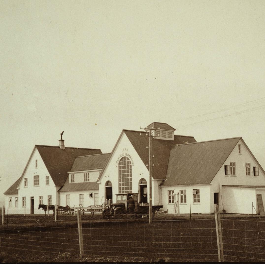 Sepia-toned photo of the Old Dairy Food Hall in Selfoss, featuring a large, historic building with multiple gables and an arched window.