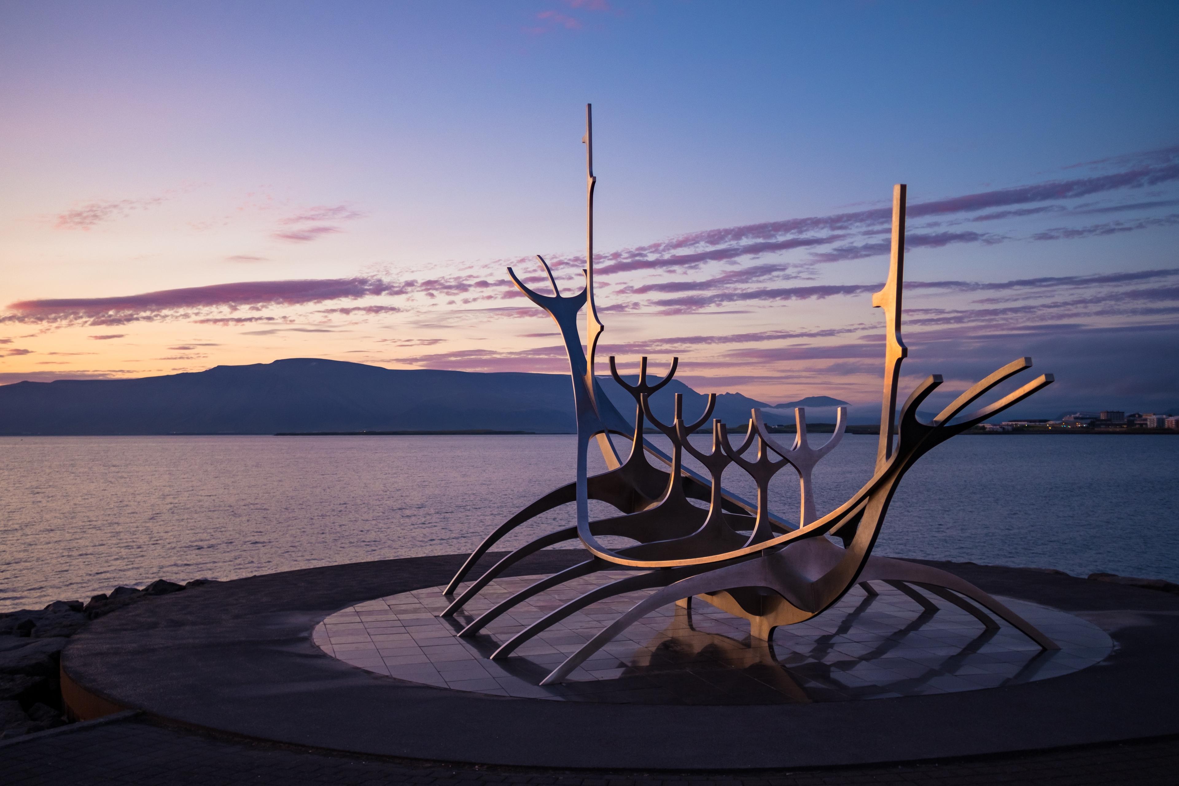 The metallic Sun Voyager sculpture bathed in the soft pink hues of sunset