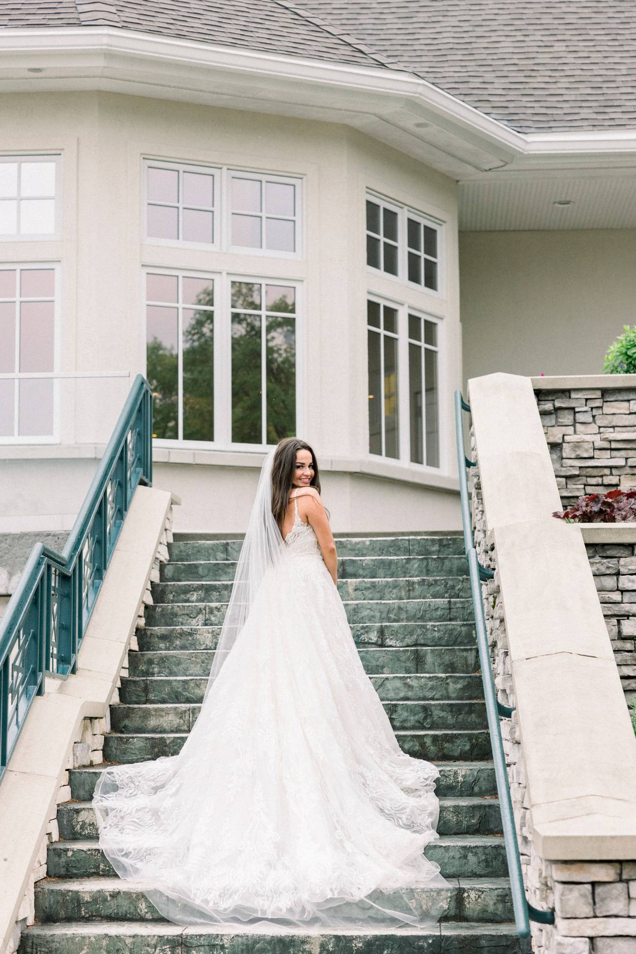 Bride poses on Bay Harbor Golf Club stairs
