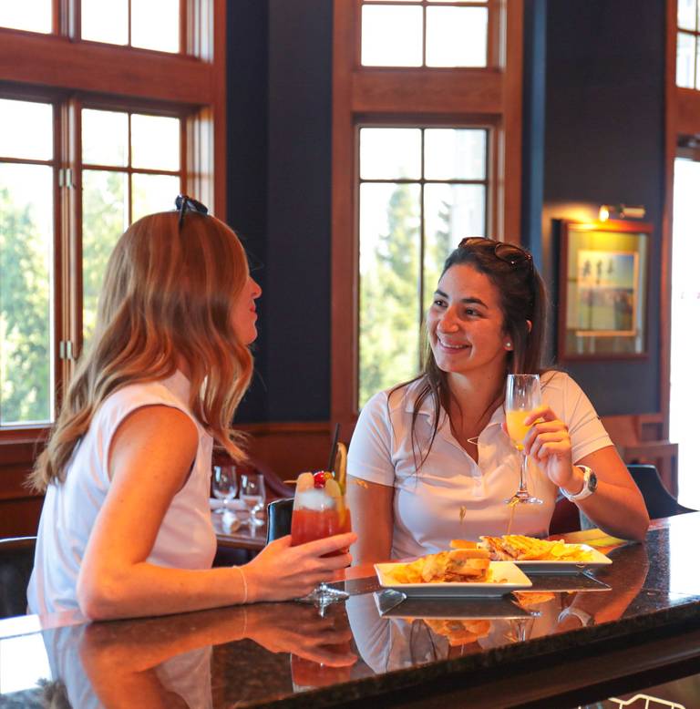 Women talking over drinks, apps, The Links Grille