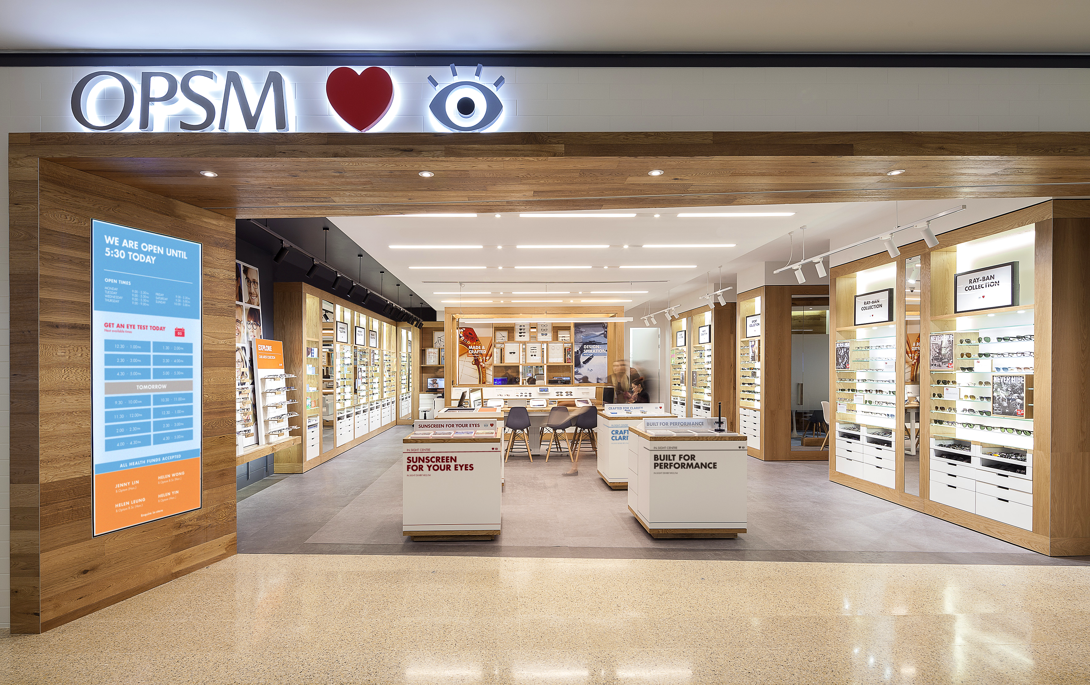 Brightly lit retail eyewear store with walls of glasses and service kiosks