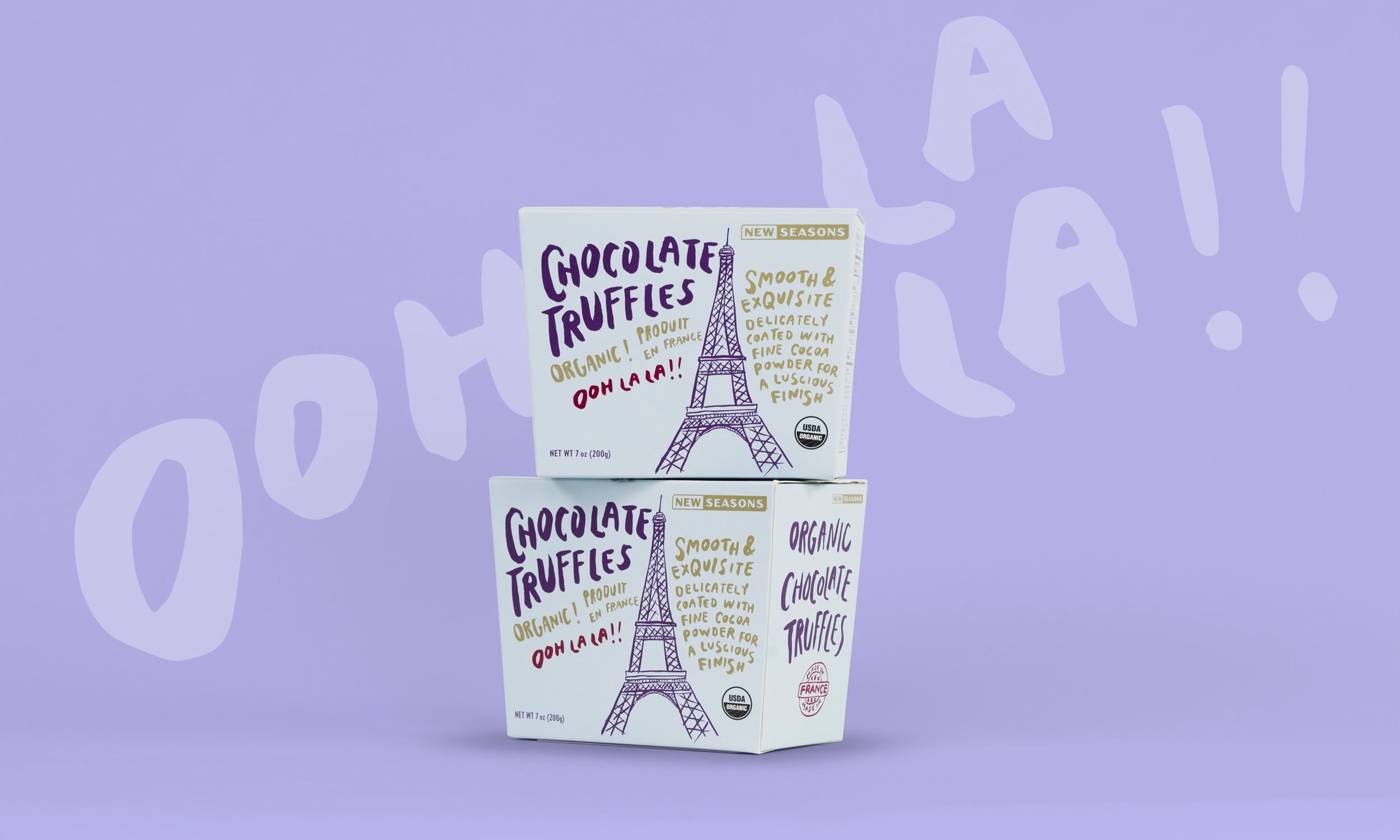 Two boxes of New Seasons chocolate truffles featuring an illustration of the Eiffel Tower, stacked on top of each other in front of a light purple background that reads “Ooh la la!”