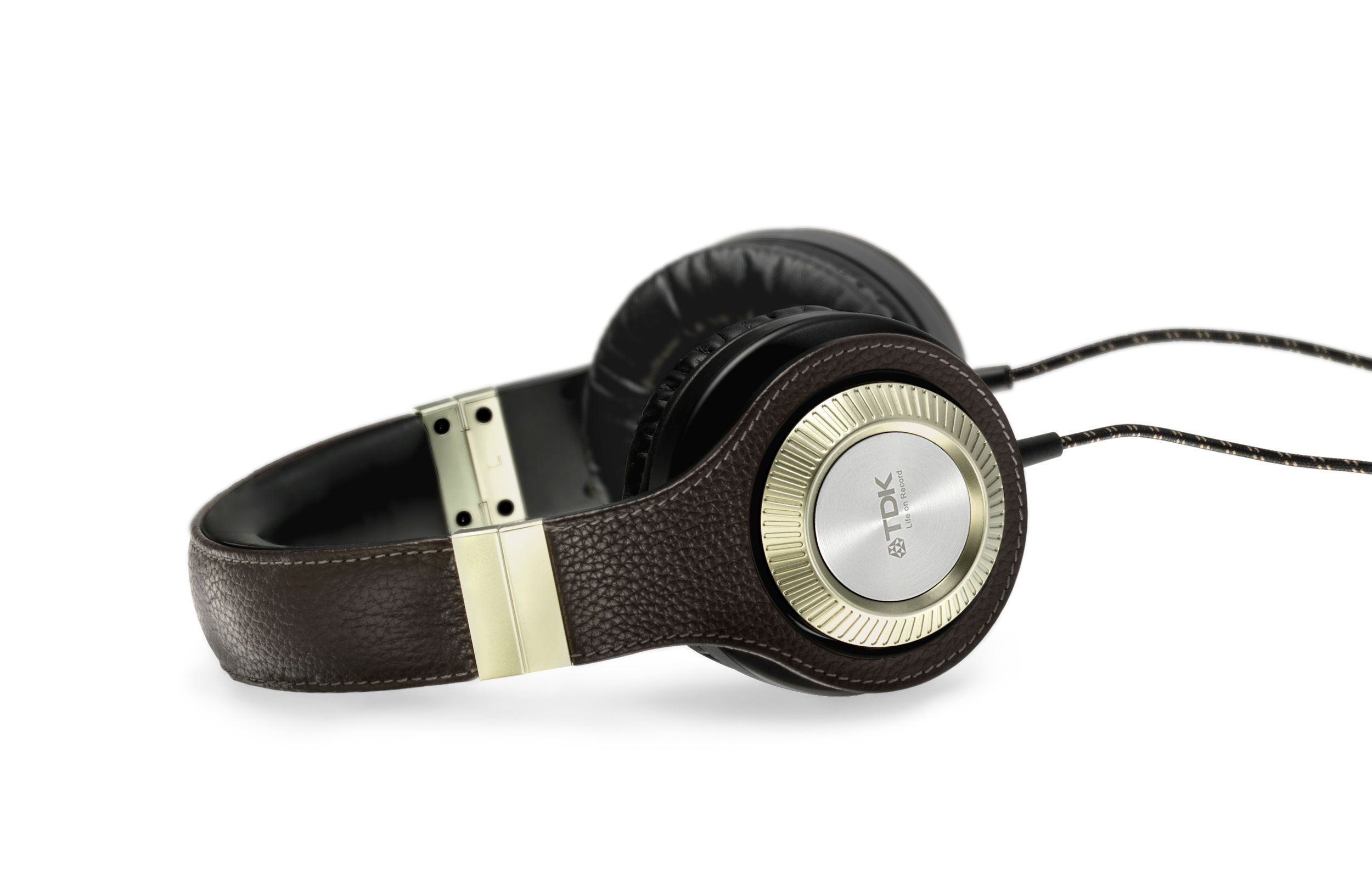 Black leather over-ear headphones that have a gold ear cover labeled “TDK, Life on Record”