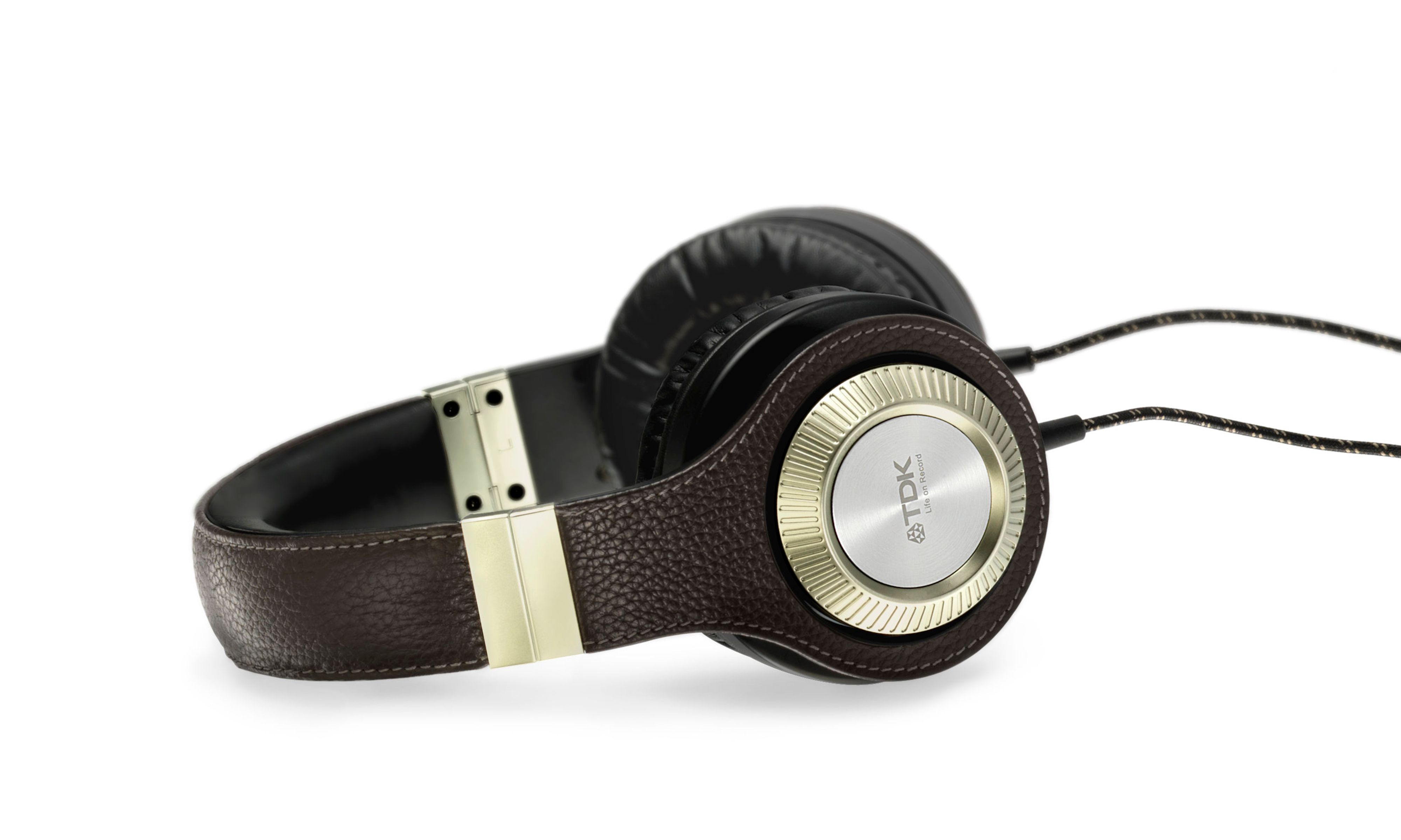 Black leather over-ear headphones that have a gold ear cover labeled “TDK, Life on Record”