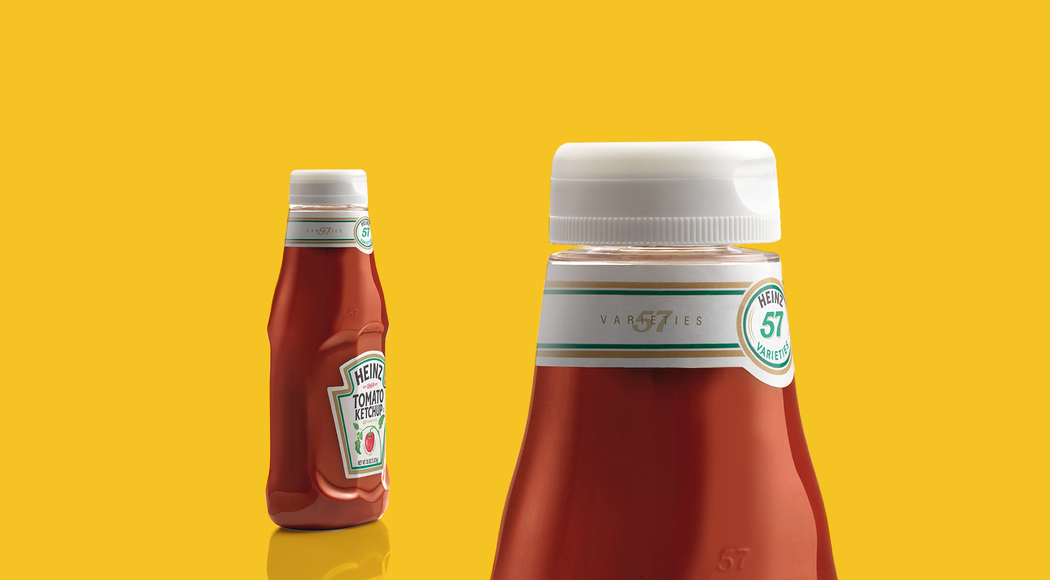 Close-up examples of a redesigned Heinz ketchup bottle placed on a yellow background