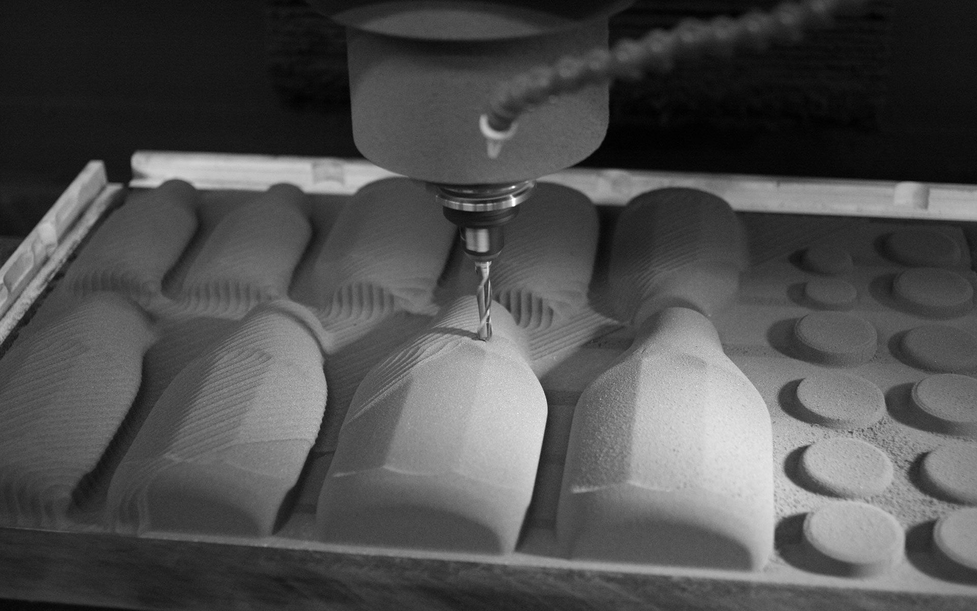 Gray foam material being machined into ketchup bottle forms