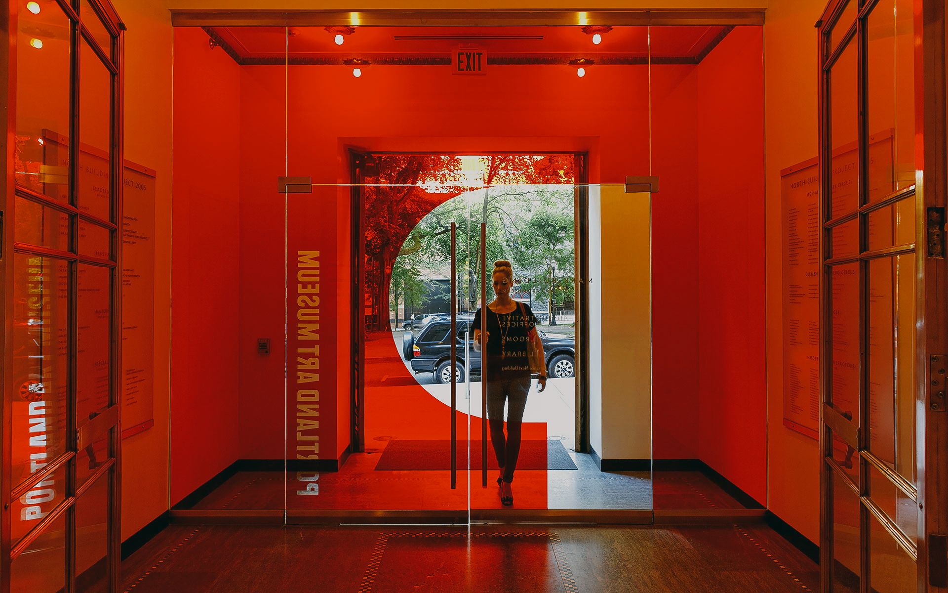 Person walking into the Portland Art Museum from an entry room that is lit in red light
