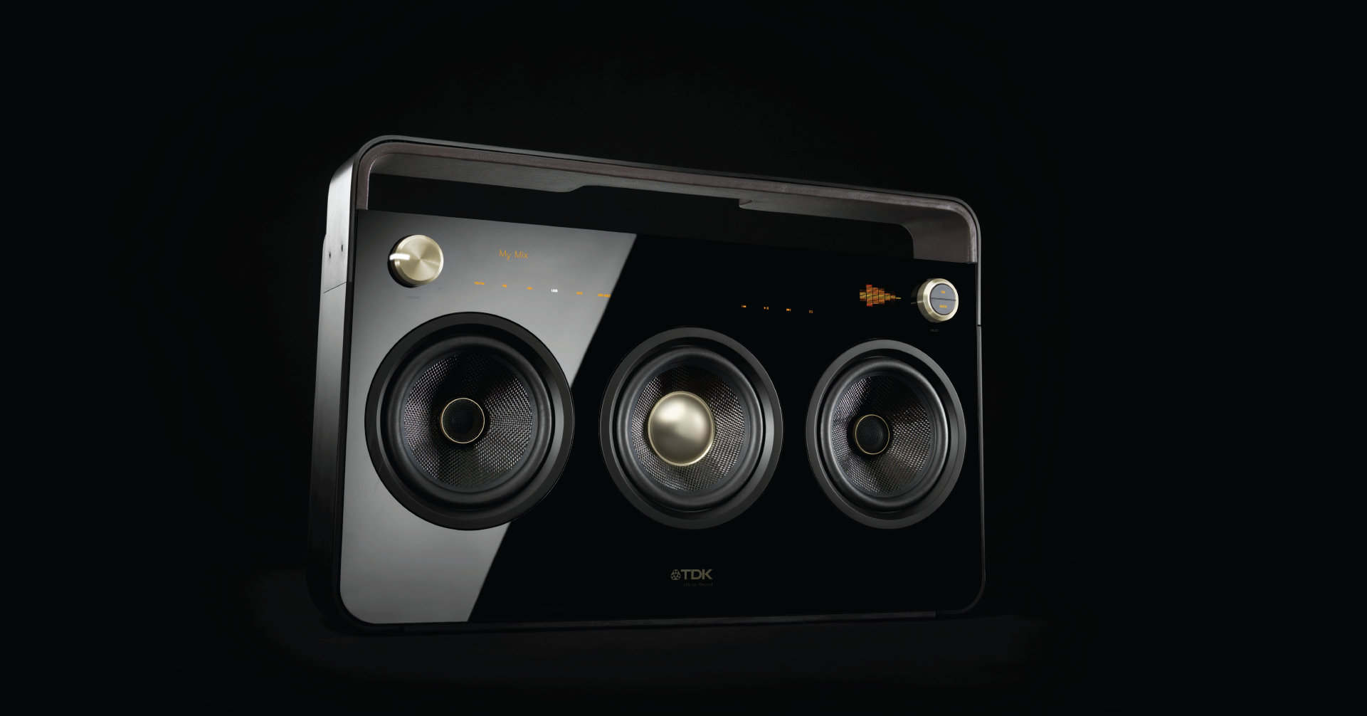 Black boombox with gold knobs, a digital interface with orange lettering, three speakers, and a solid plastic black handle on top