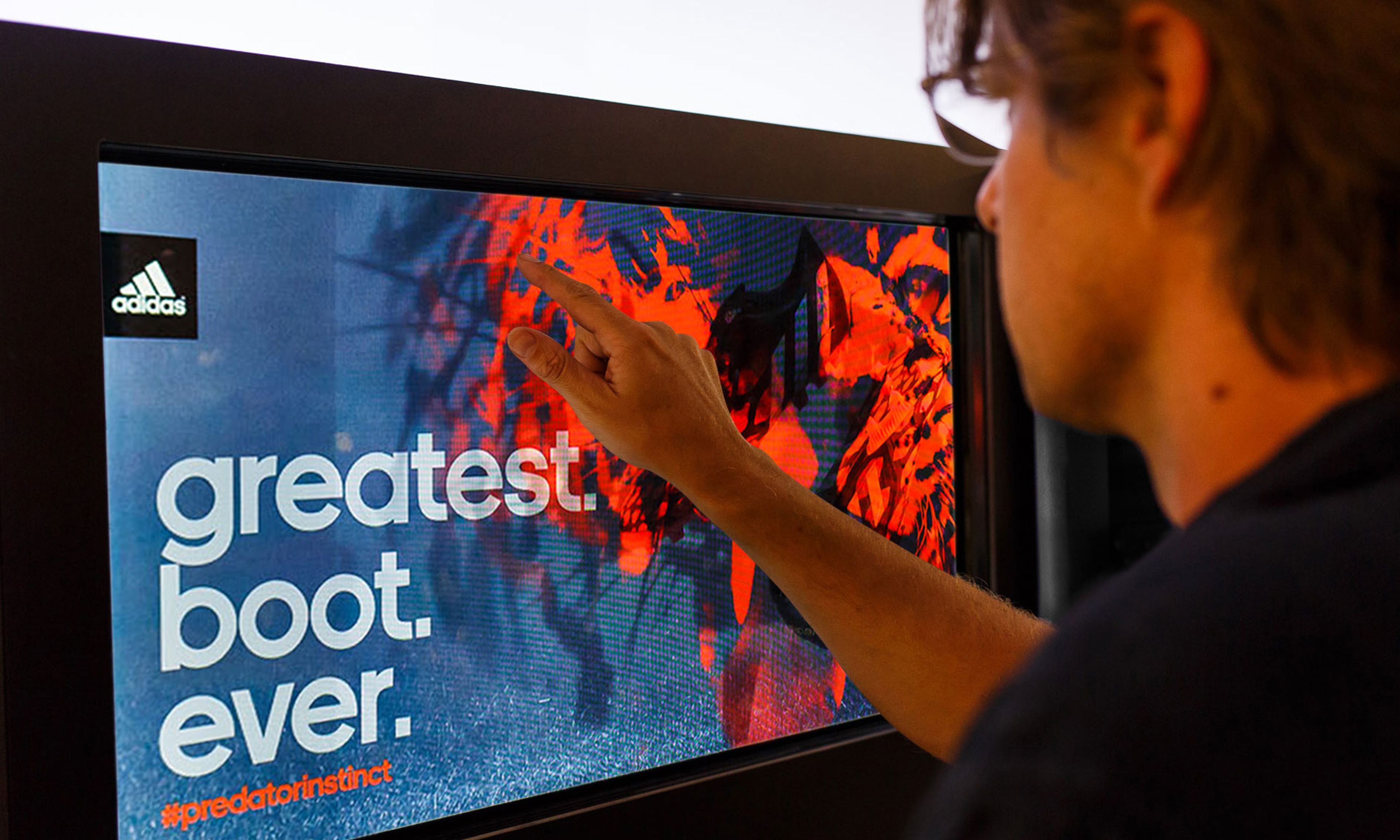 Person touching a touch screen that reads “Greatest. Boot. Ever.”