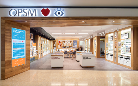 Brightly lit retail eyewear store with walls of glasses and service kiosks