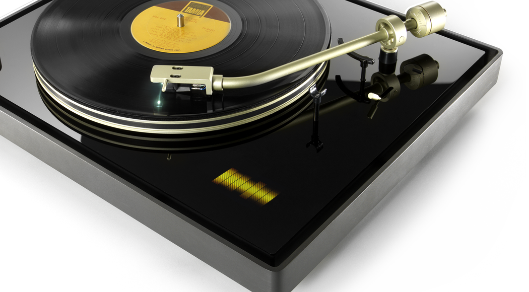 Black record player spinning a record, with a gold needle arm and a digital interface showing orange audio waves