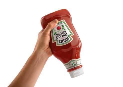 Hand holding a Heinz ketchup bottle upside down
