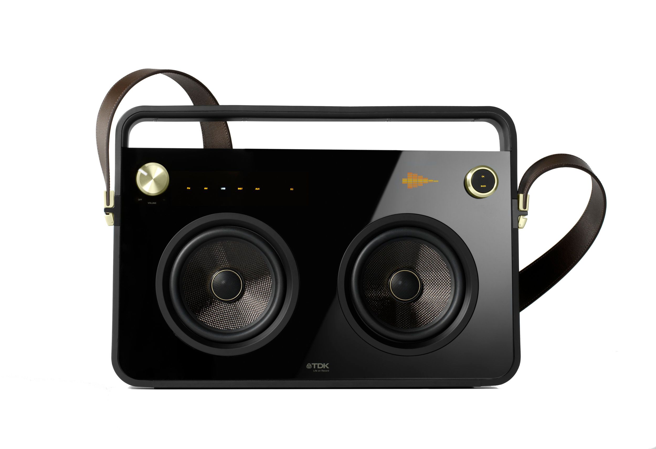 Black boombox with a gold knob in the top left, two speakers in the middle, and a brown leather strap buckled to the sides
