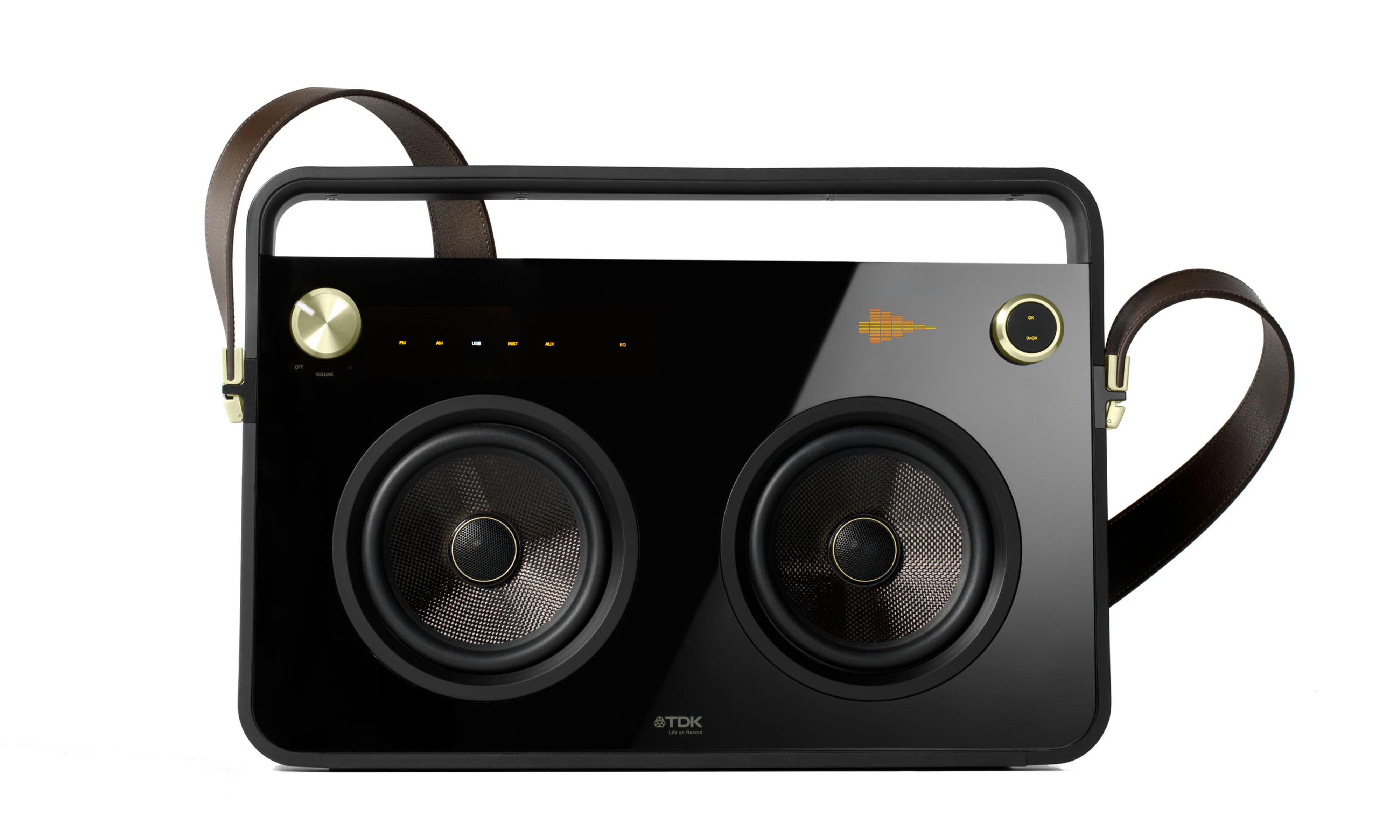 Black boombox with a gold knob in the top left, two speakers in the middle, and a brown leather strap buckled to the sides