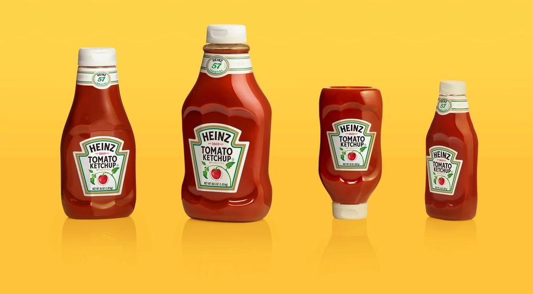 Four examples of a redesigned Heinz ketchup bottle in different sizes and form factors, placed on a yellow background