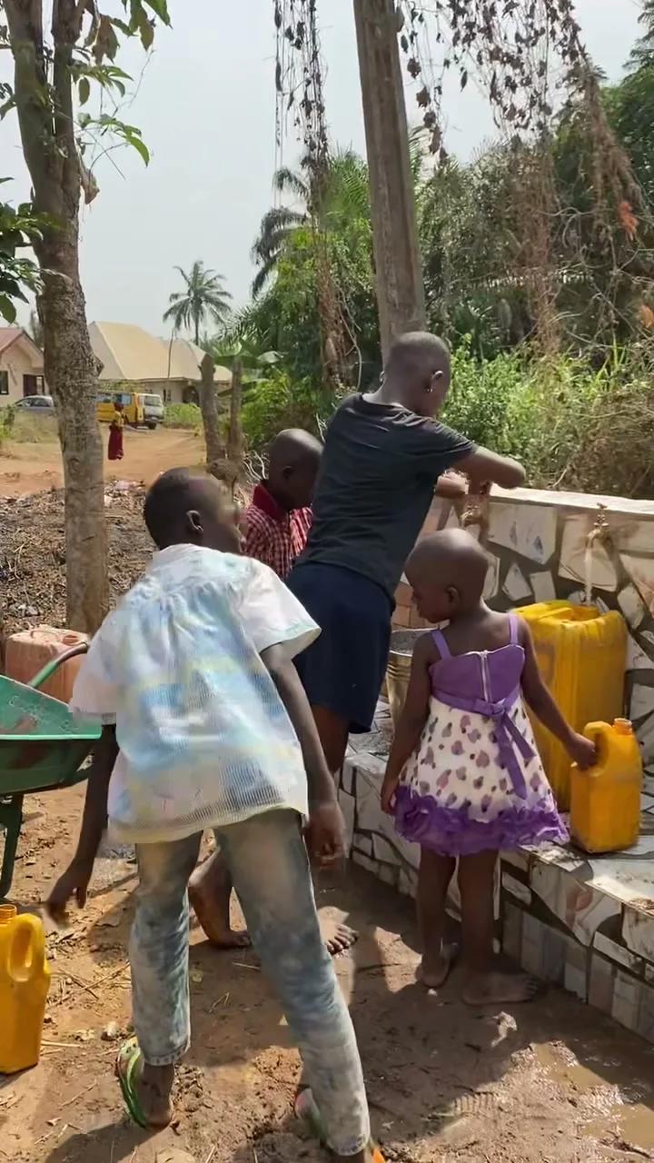 Children standing near a completed Give Water Give Life water system.