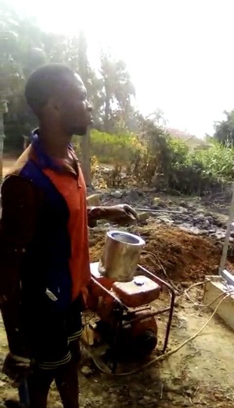 A worker with equipment beside the completed borehole.