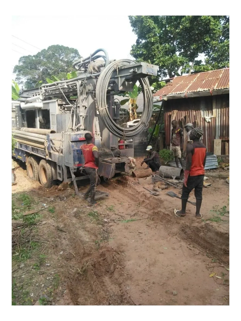 A drilling truck and workers at the work site.