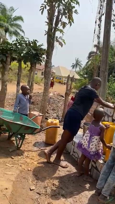 People filling containers at the completed water point.