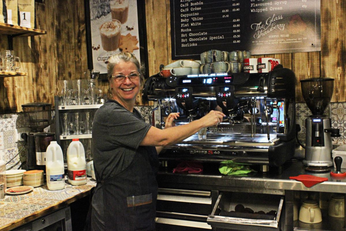 Glass Strawberry customer smiling at camera with La Spaziale coffee machine