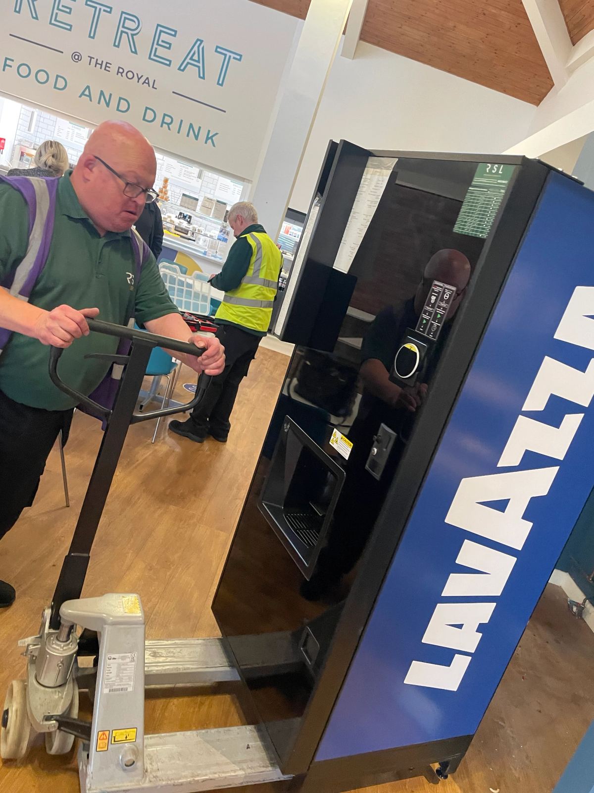 Man installing a Neo Coffee machine with Lavazza branding
