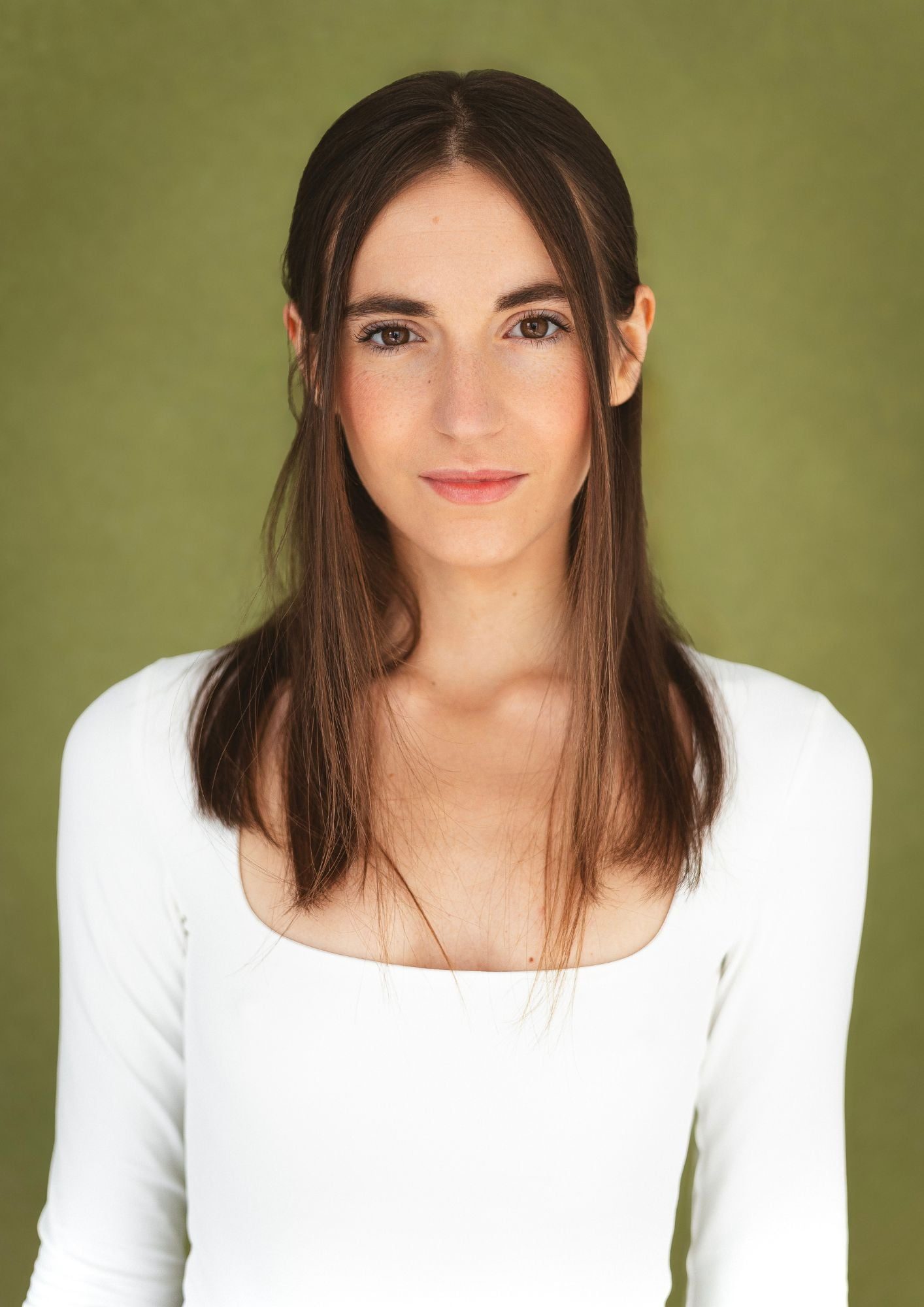 Retrato de Cecilia Mansilla con camiseta blanca sobre fondo verde oliva