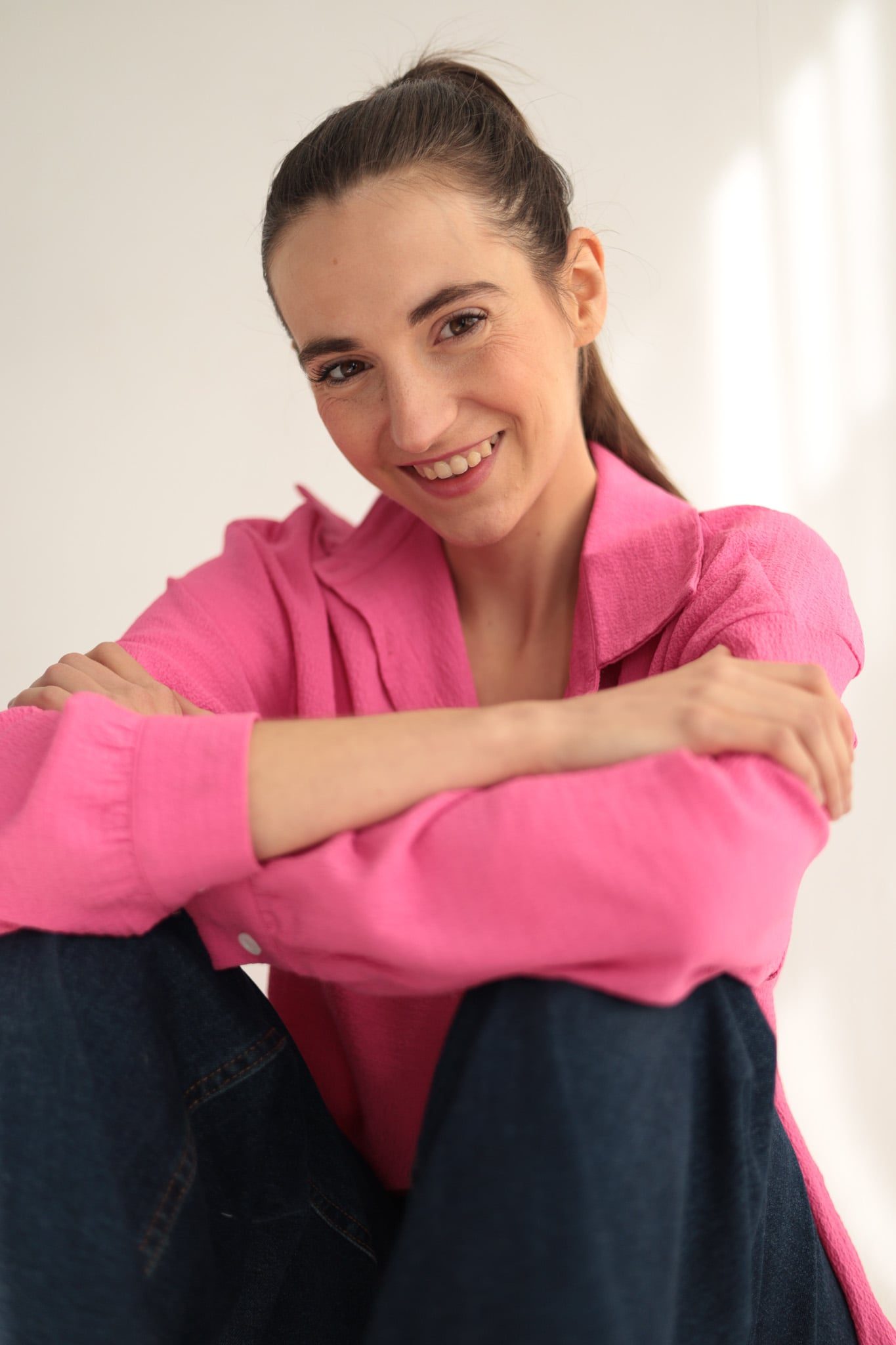 Cecilia Mansilla sentada con camisa rosa, sonriendo