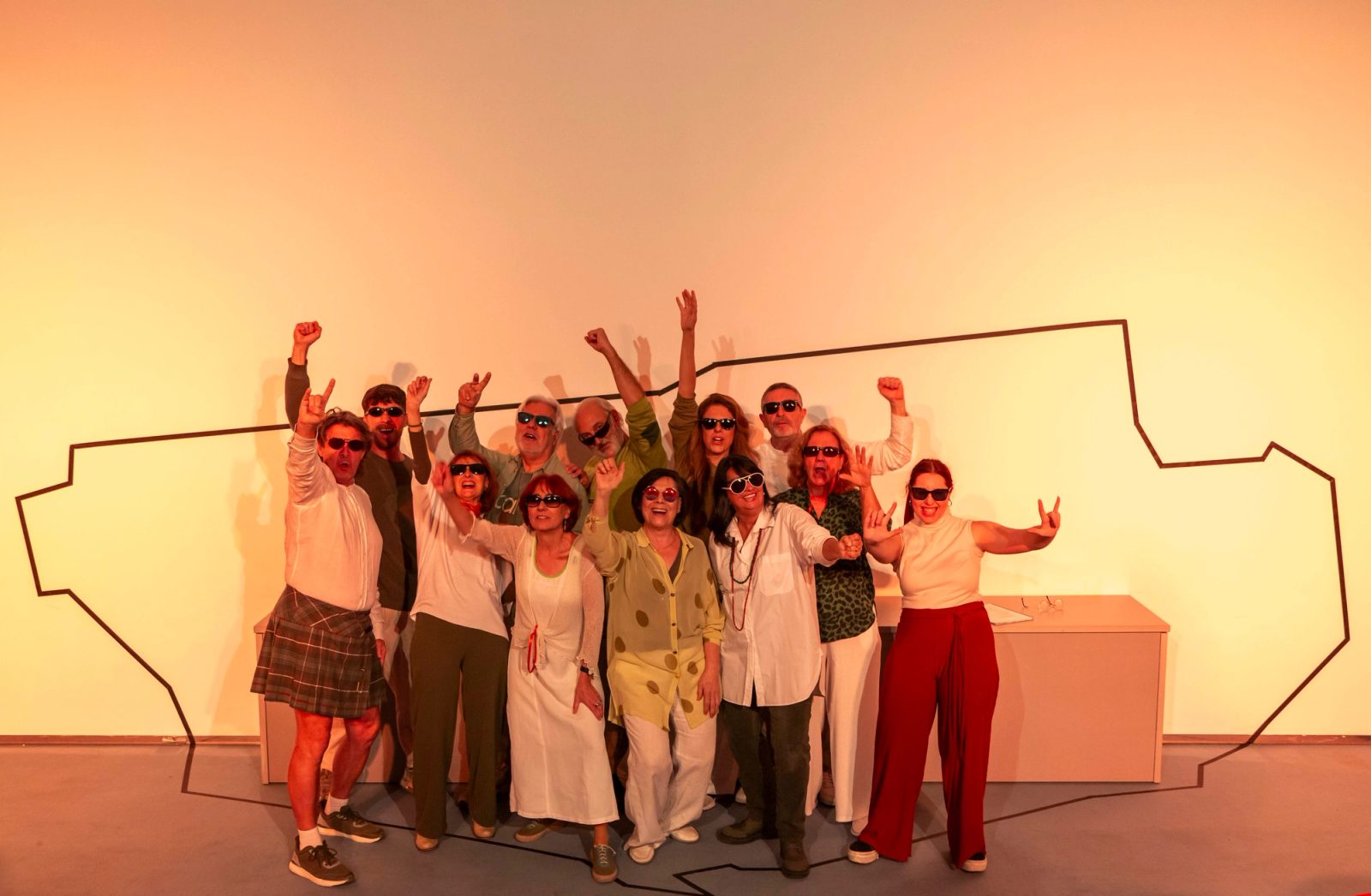 Foto de grupo con los brazos en alto celebrando el final de la función
