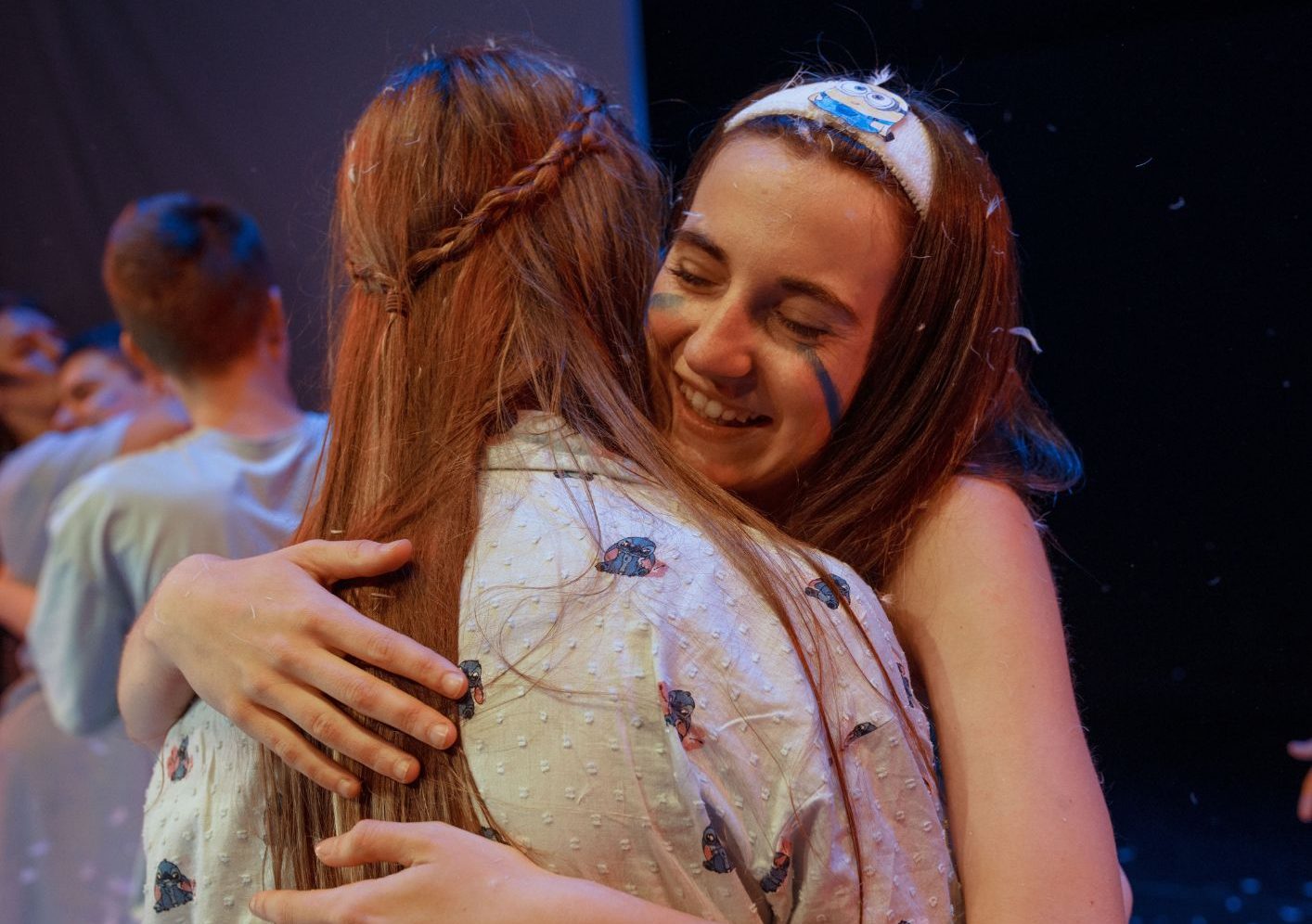 Dos adolescentes abrazándose y sonriendo al final de una función