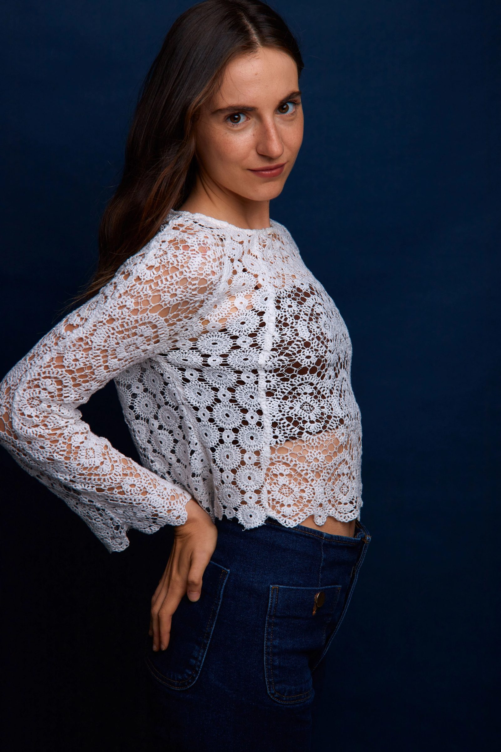 Retrato de Cecilia Mansilla de perfil, con blusa blanca de encaje sobre fondo azul
