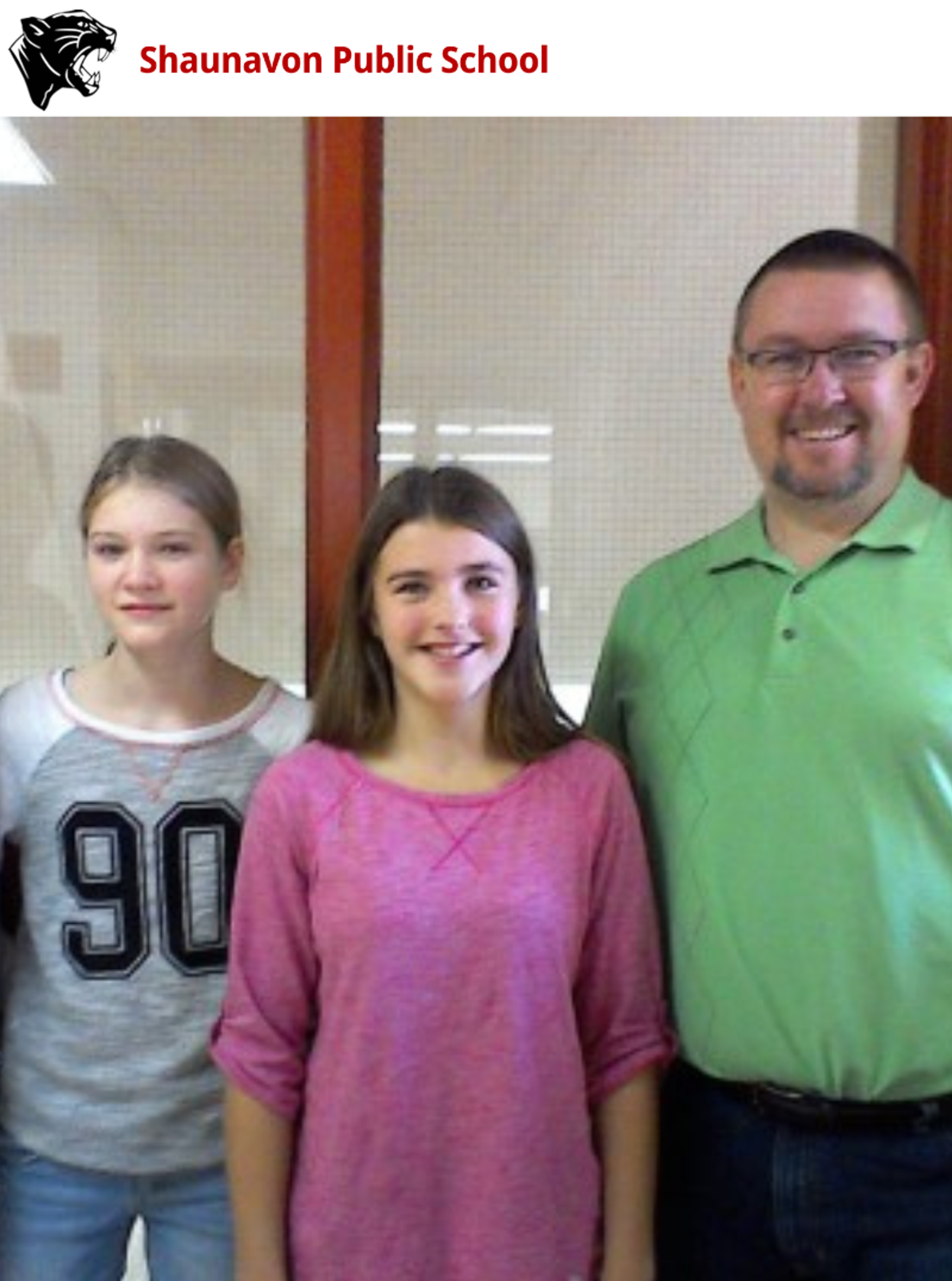 Two students and a teacher from Shaunavon Public School pose together indoors.