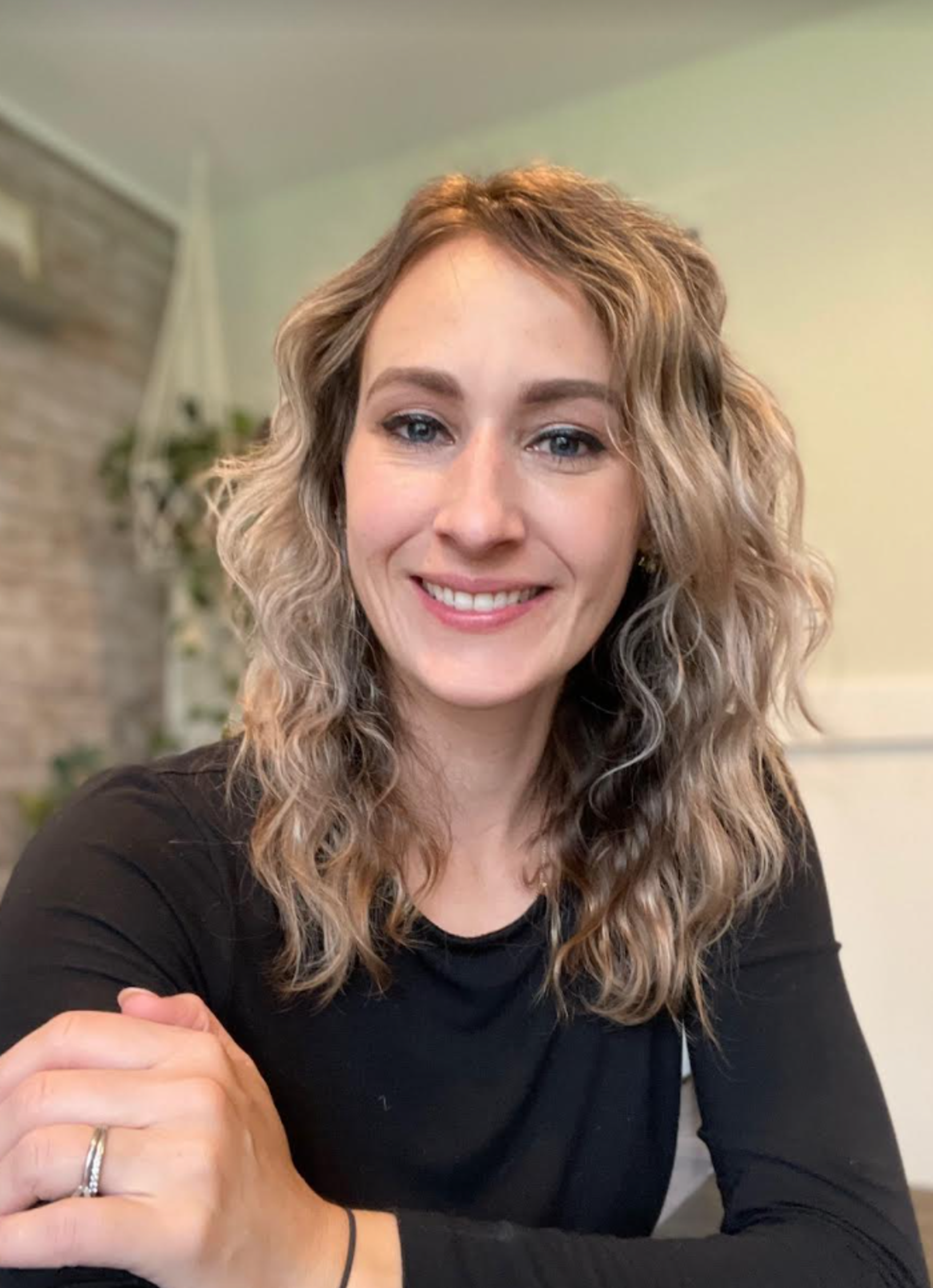 Headshot of Melanie Kril, smiling seated indoors.
